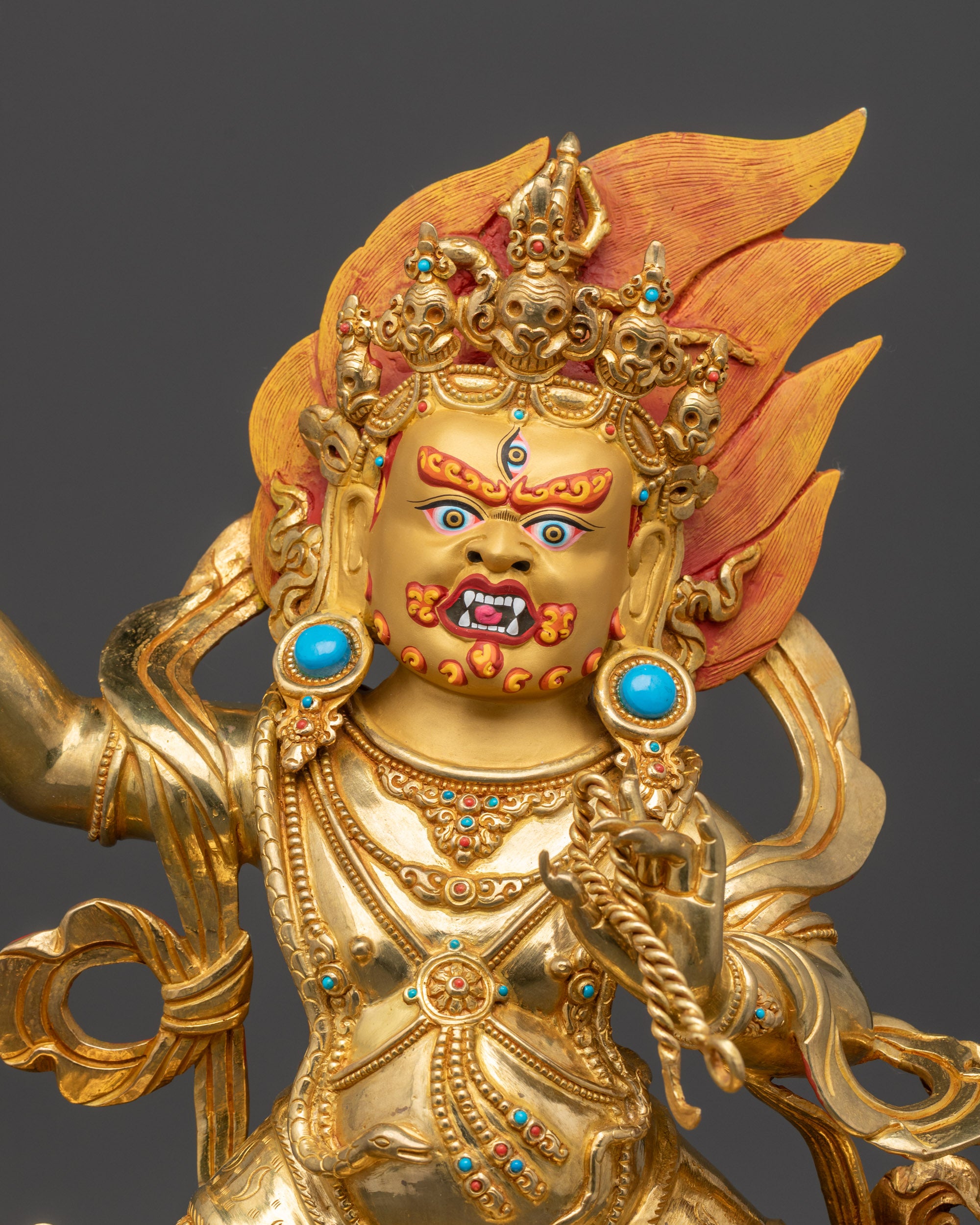 Close up Vajrapani statue showing hand-carved robe, vajra, and lasso details