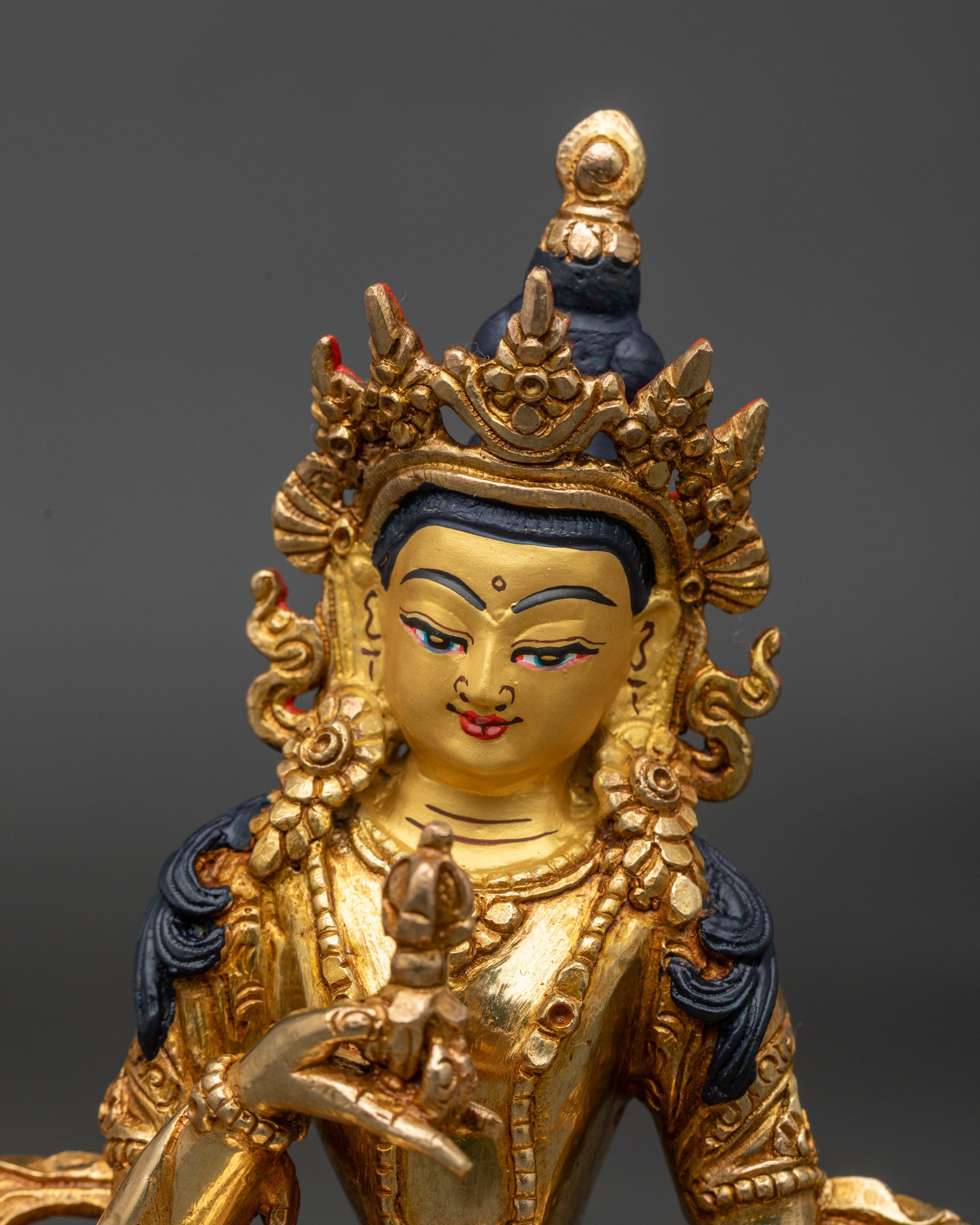 Close up Vajrasattva Buddha statue gold-painted face Himalayan craftsmanship