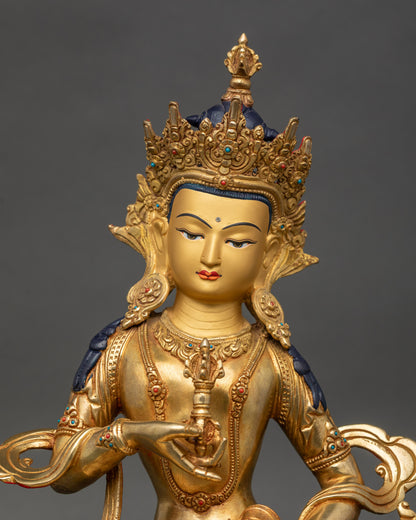 Close up Vajrasattva statue showing gold-painted face, semi-precious stones, and crown