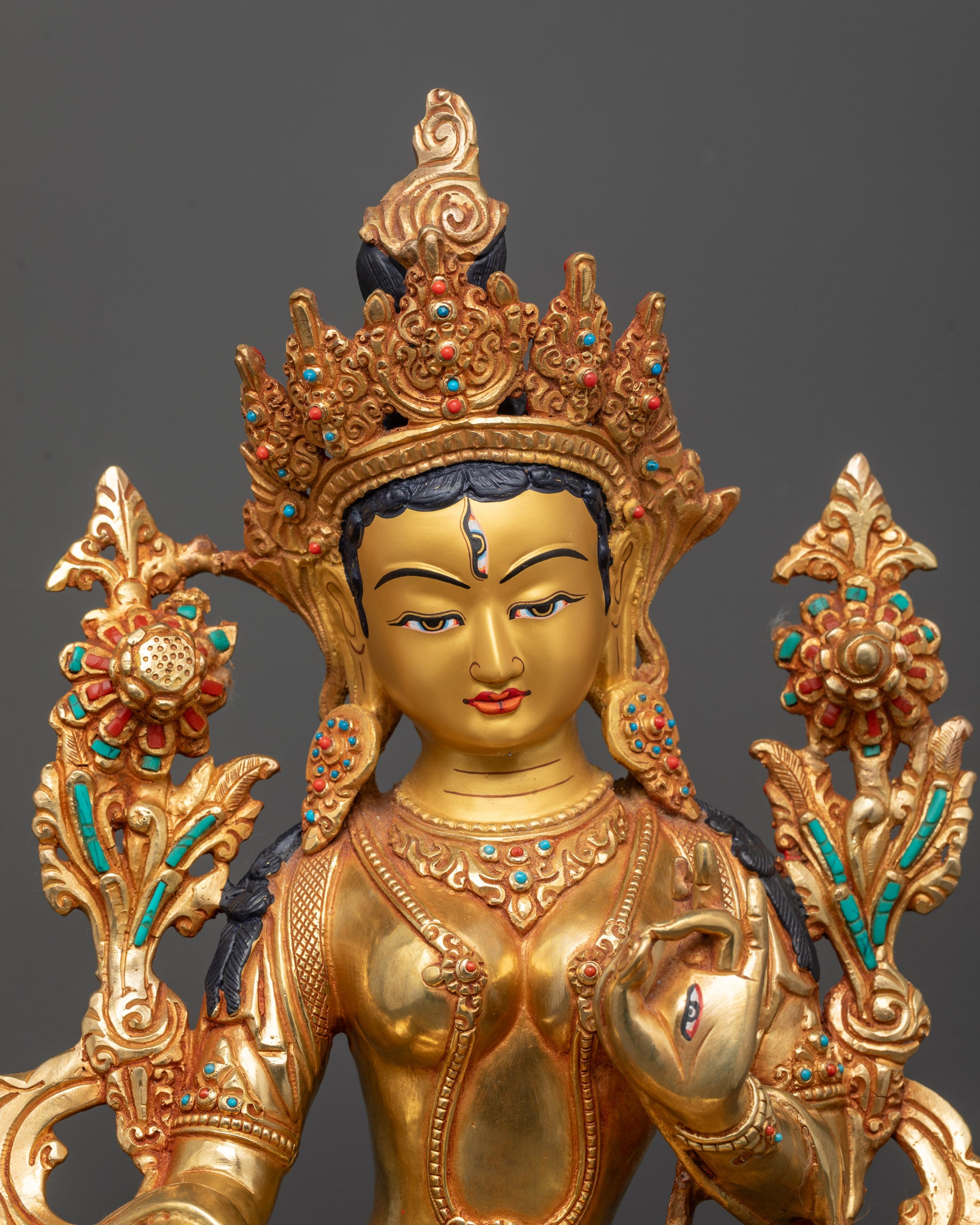 Close up White Tara Buddhist statue adorned with coral, lapis lazuli, and turquoise