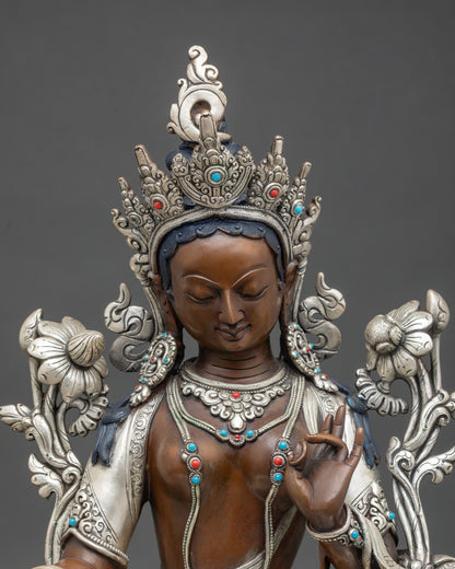 Close up White Tara face with gold-painted features, crown, jewelry, and Utpala flower