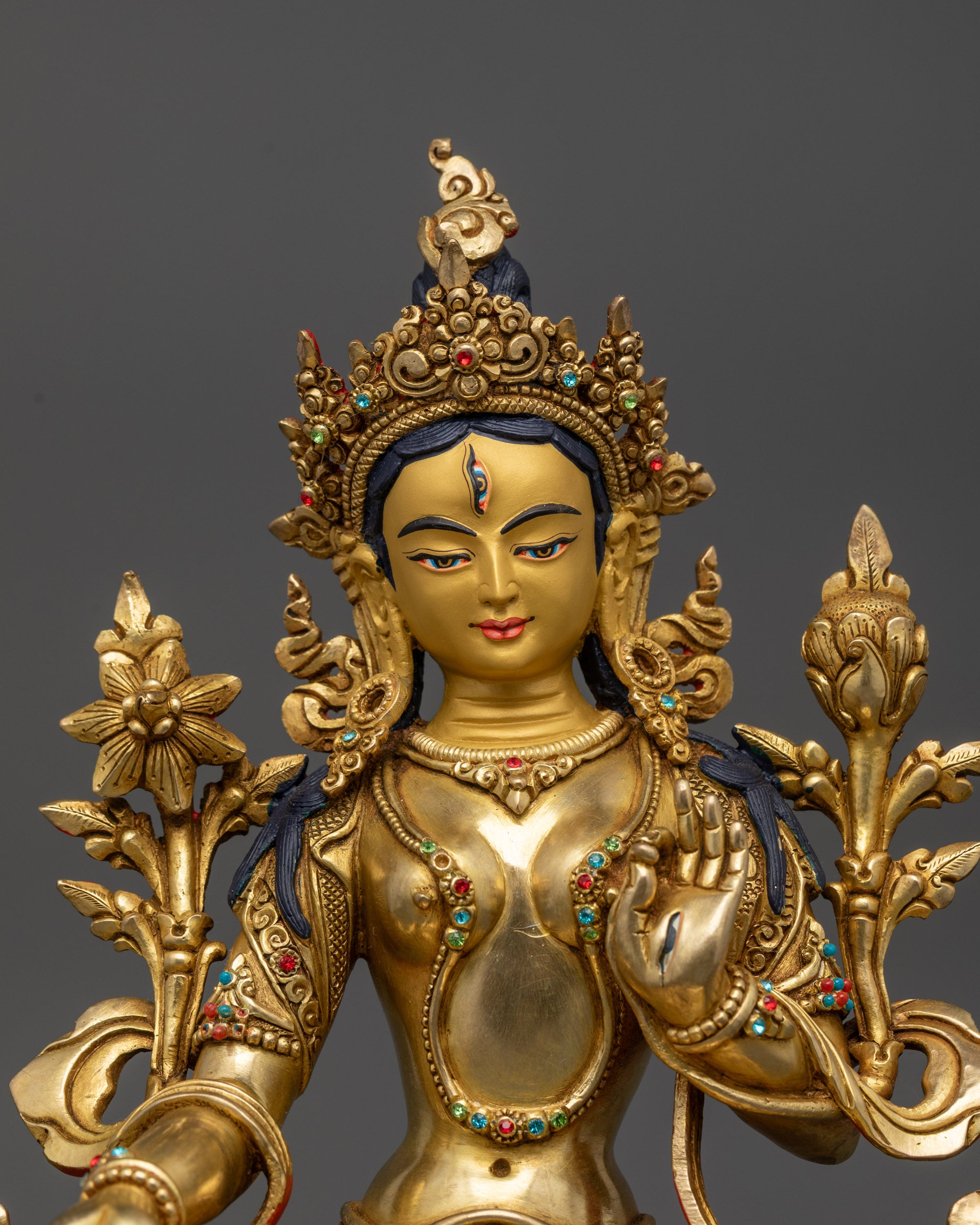 Close up White Tara’s face with seven seeing eyes and gold-gilded details