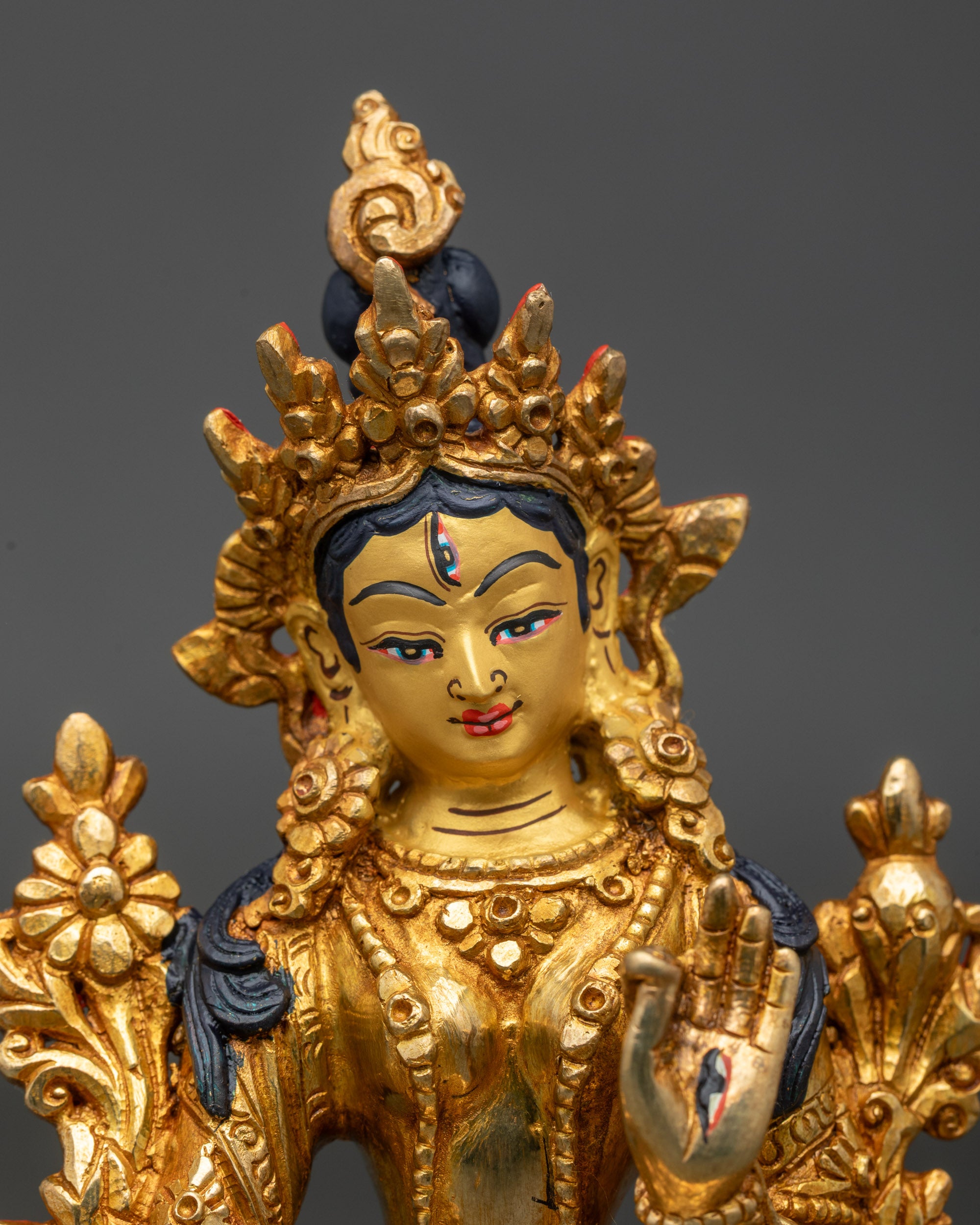 Close up White Tara statue seven eyes gold-painted face Himalayan craftsmanship