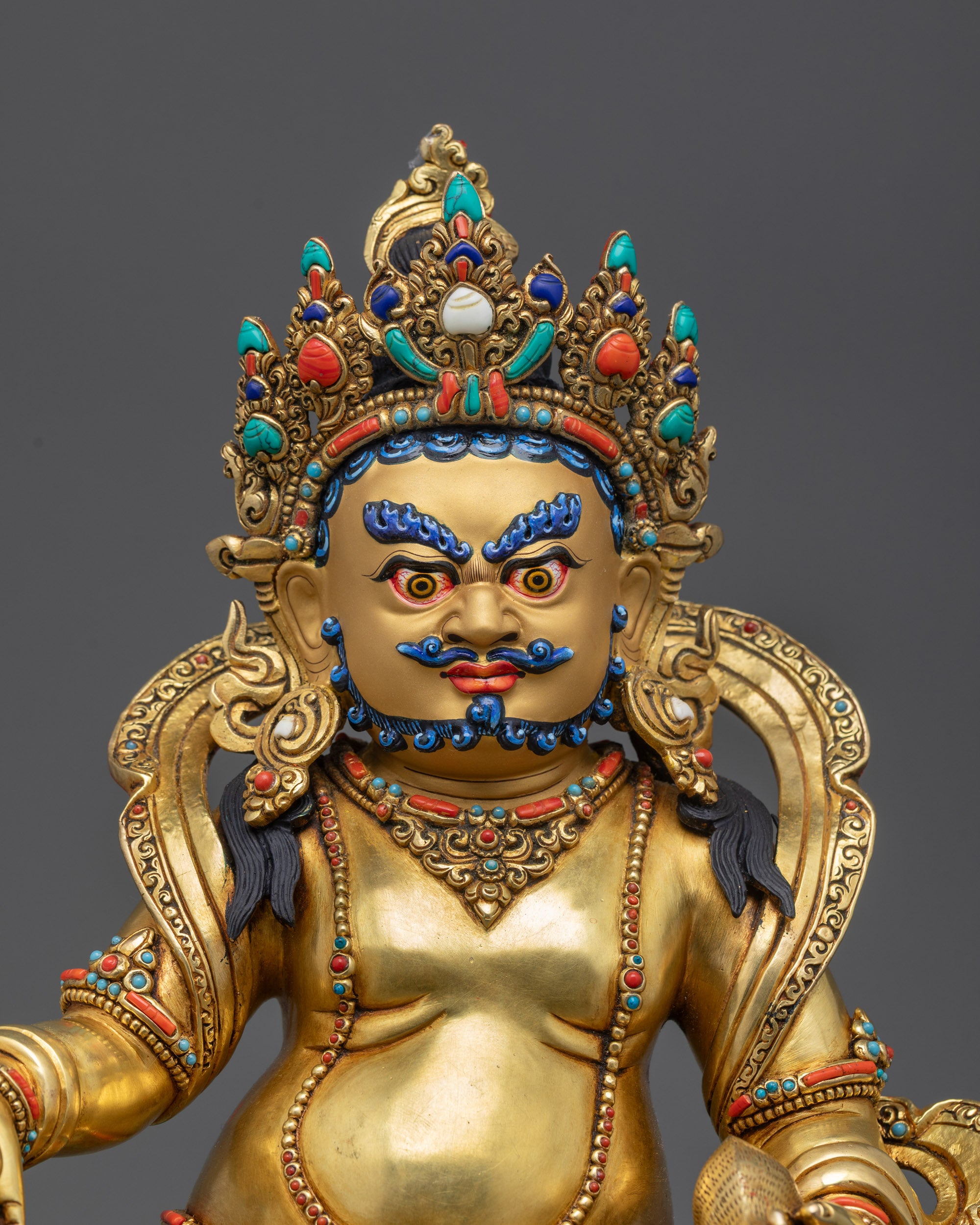 Close up Yellow Dzambhala Statue showing ornate crown and gemstone details