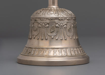 Close up angled view of bronze bell with handle and hand-carved sacred deity