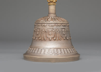 Close up bronze bell with carved copper deity handle for meditation and puja