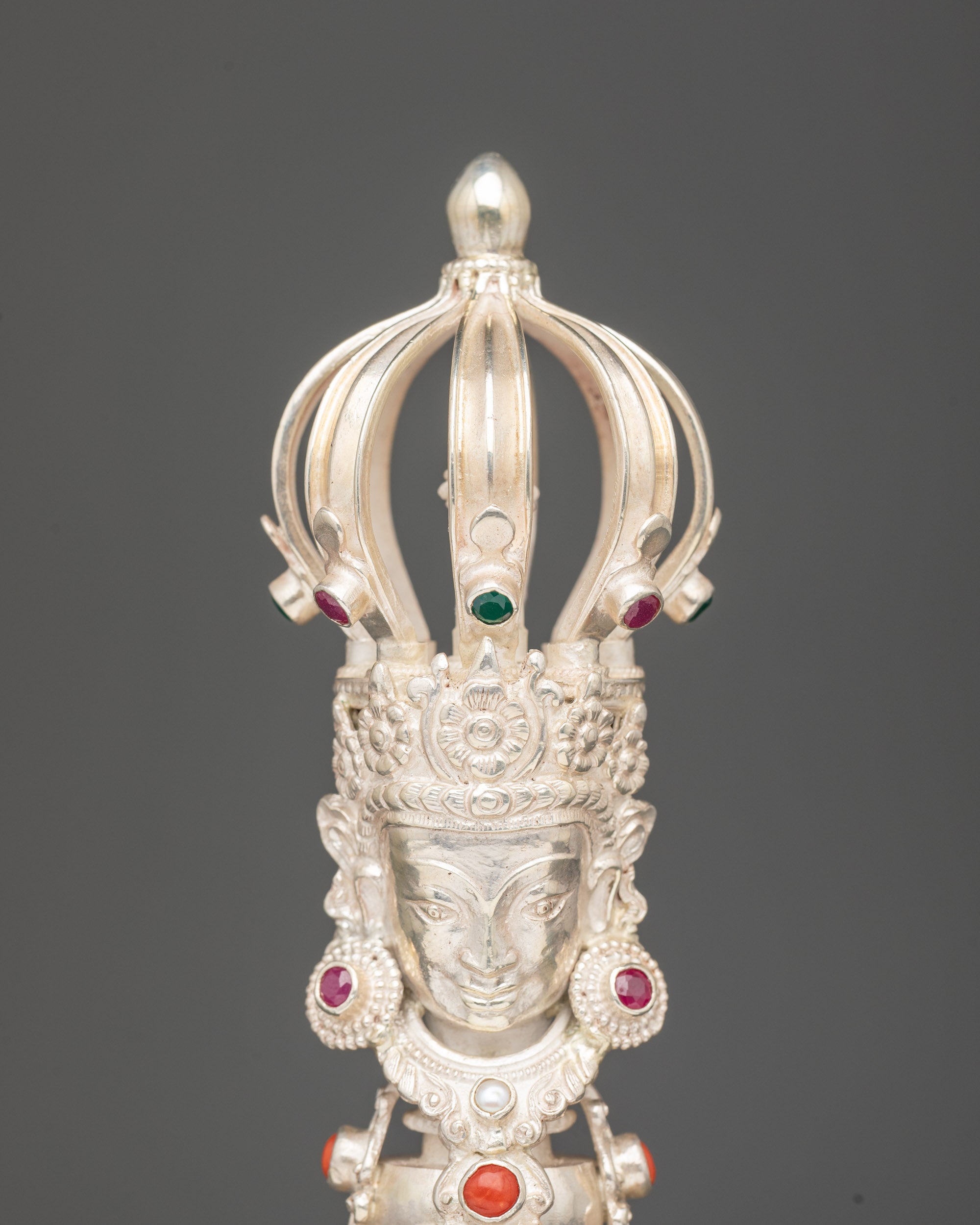 Close up bronze bell with silver handle deity carved with five jewelled crown