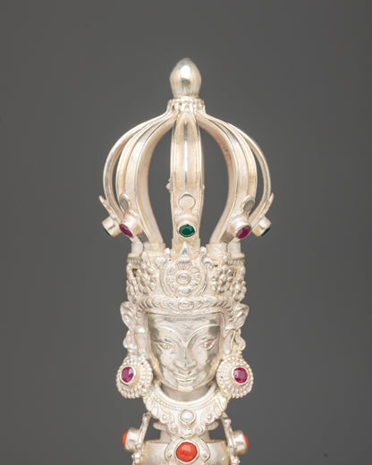 Close up bronze bell with silver handle deity carved with five jewelled crown