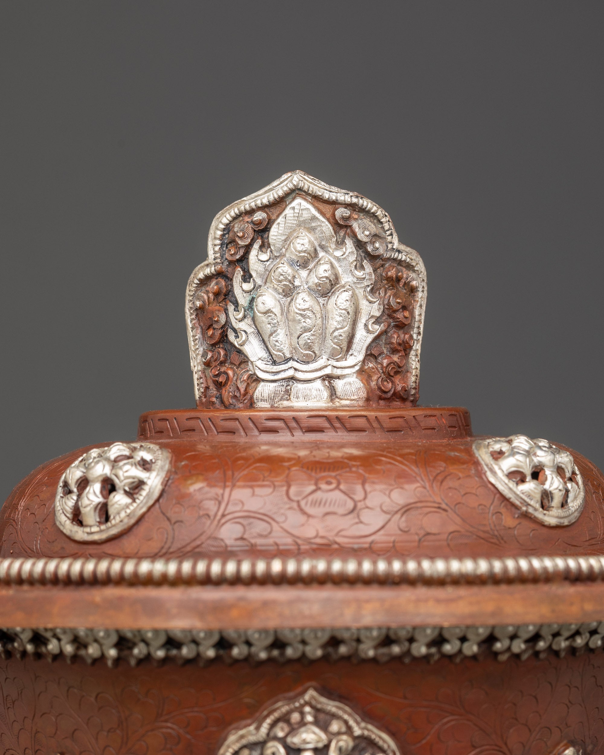 Close up decorative silver finial on Tibetan butter lamp representing enlightenment