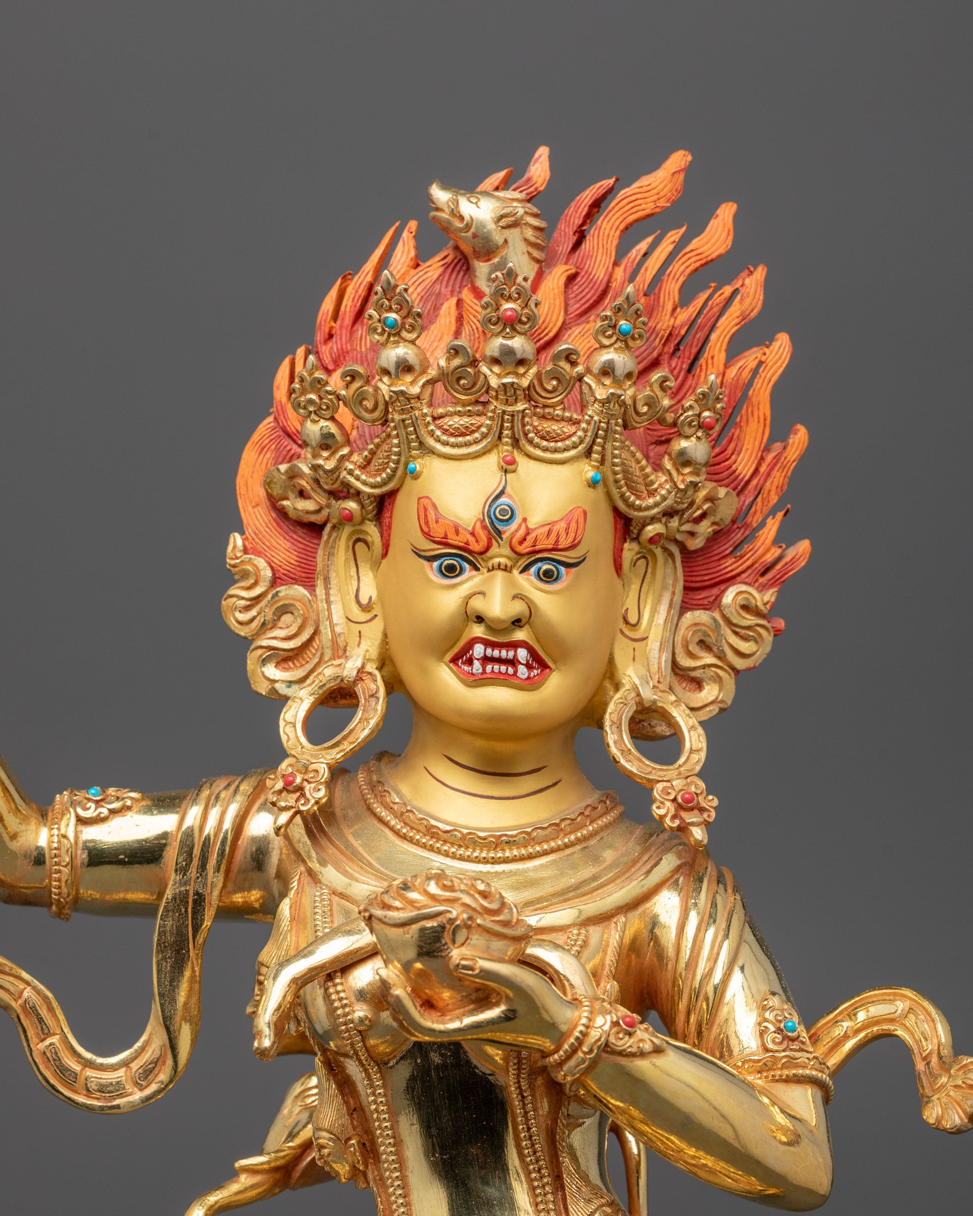 Close up detail of Troma Nagmo statue third eye, fierce face, and gold fire gilded finish