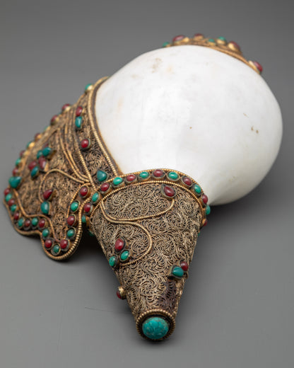 Close up detailed filigree design with semi-precious stones on handcrafted Tibetan conch shell