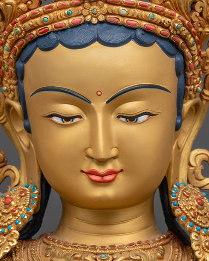 Close up face of Green Tara Statue showing serene gold-gilded expression