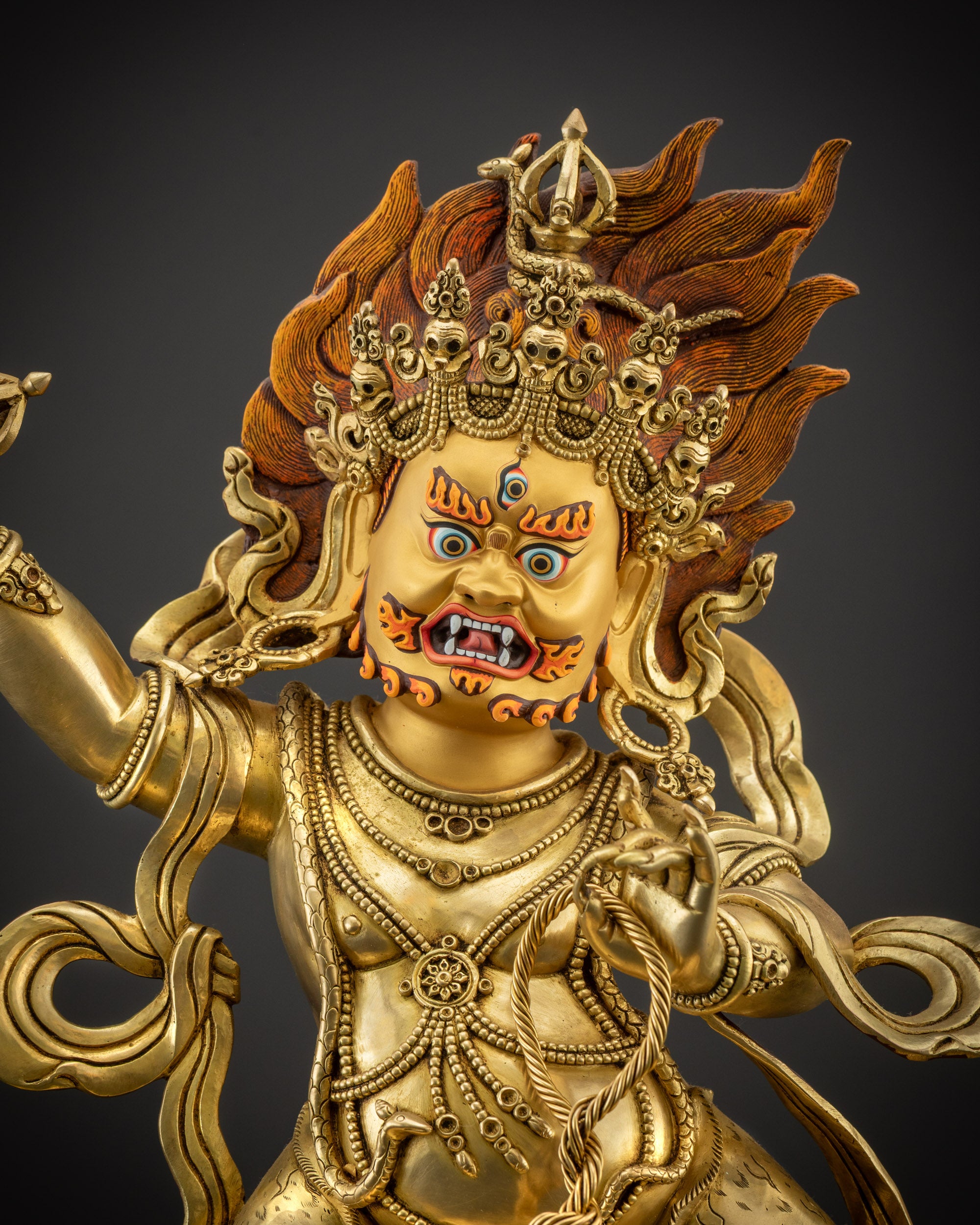 Close up face of Vajrapani statue with skull crown and third eye
