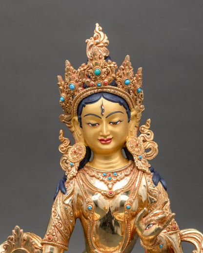 Close up gold-painted face Dukar statue with turquoise and coral stones Nepal