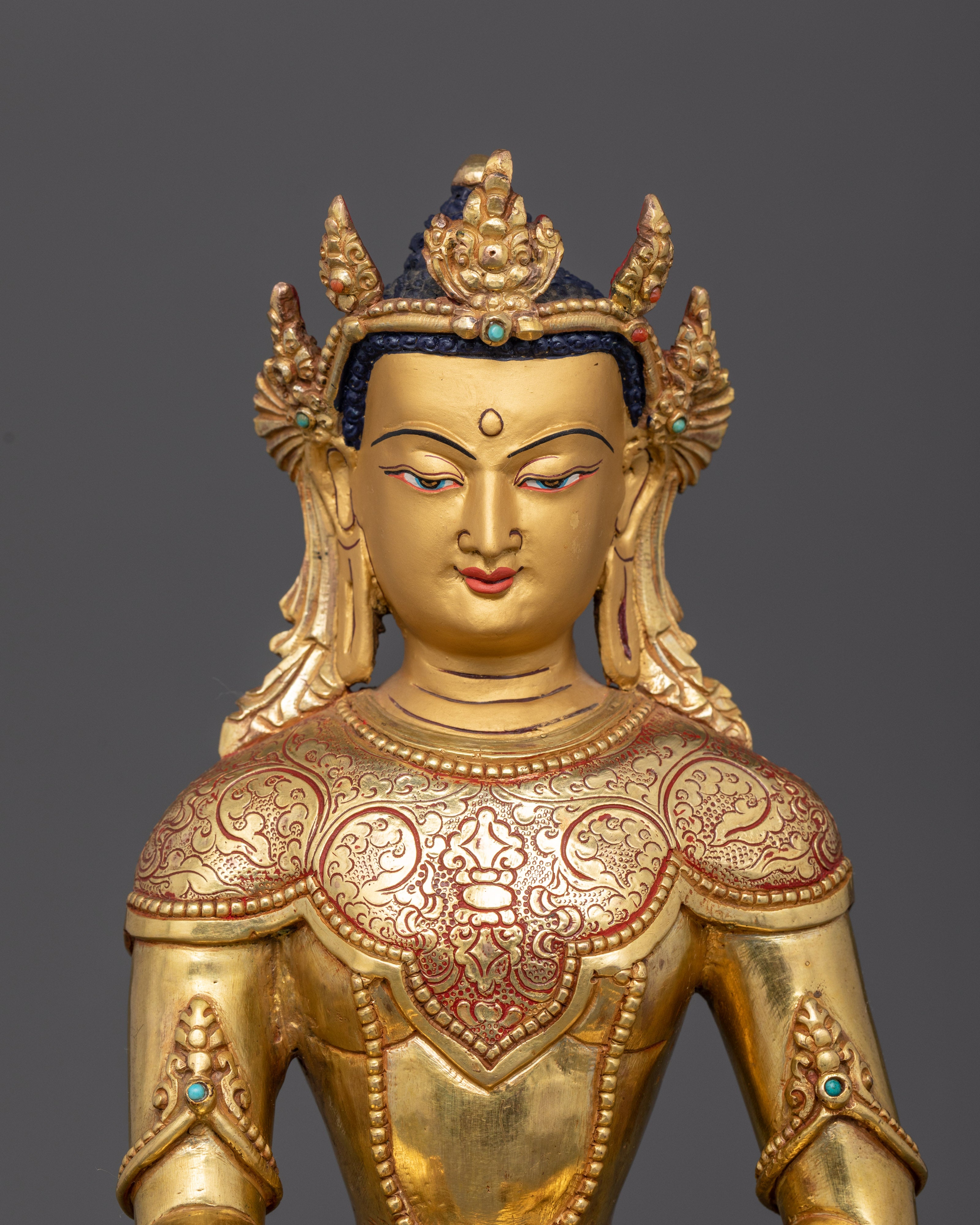 Close up gold-painted face five jeweled crown semi-precious stones detail