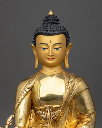 Close up gold-painted face of Medicine Buddha, handcrafted Nepal Buddhist statue