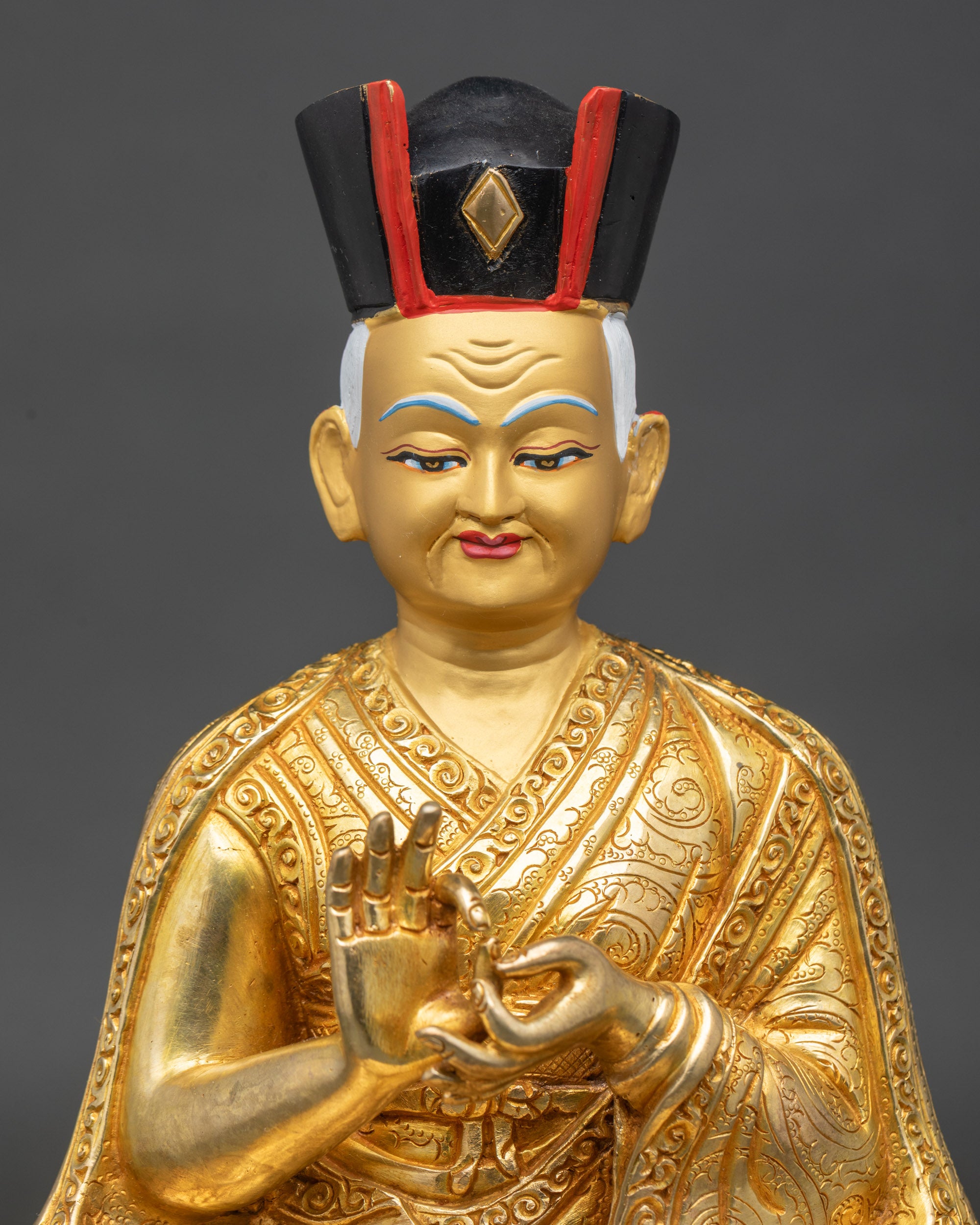 Close up gold painted face 1st Karmapa Dusum Khyenpa statue Black Crown detail