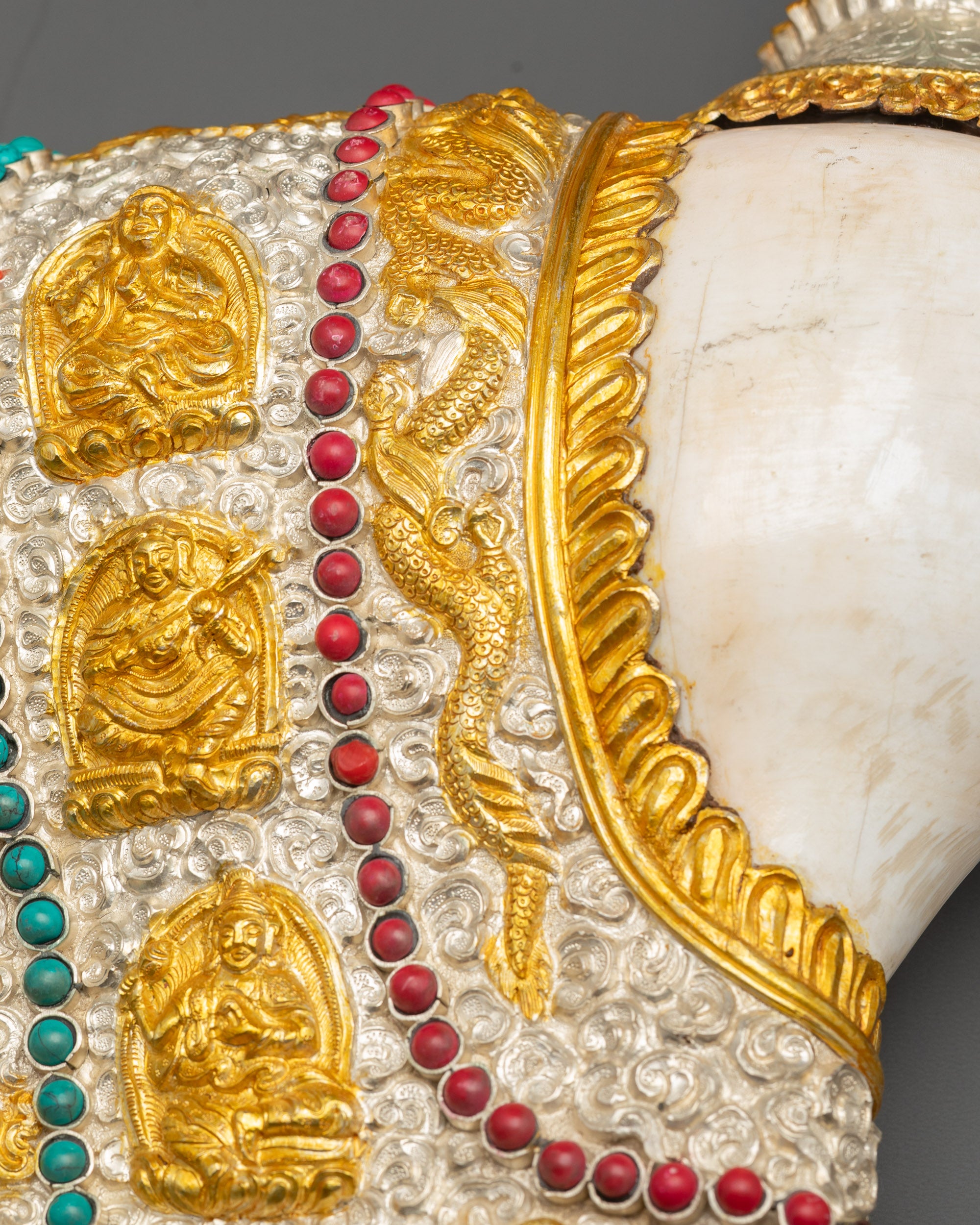 Close-up handcrafted Himalayan conch shell depicting Buddhist masters 