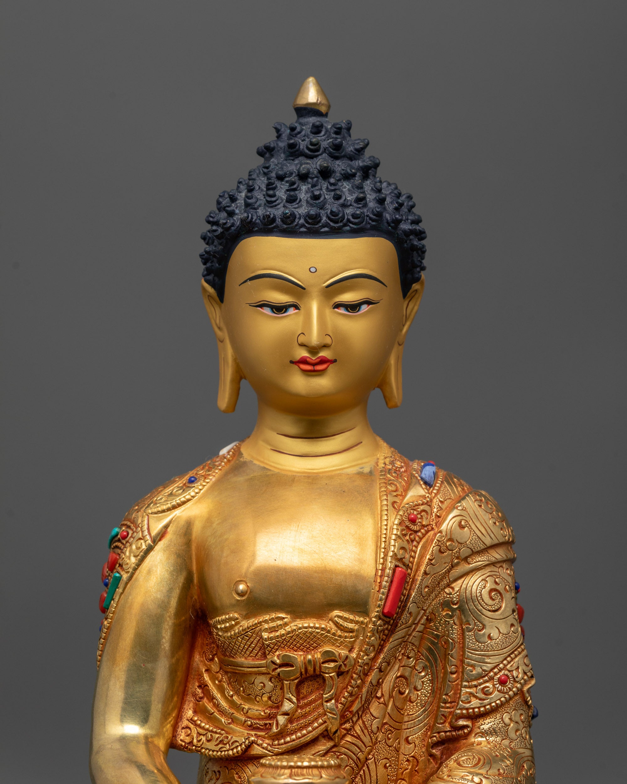 Close up of Amida Nyorai Buddha showing intricate robe patterns and semi-precious stones