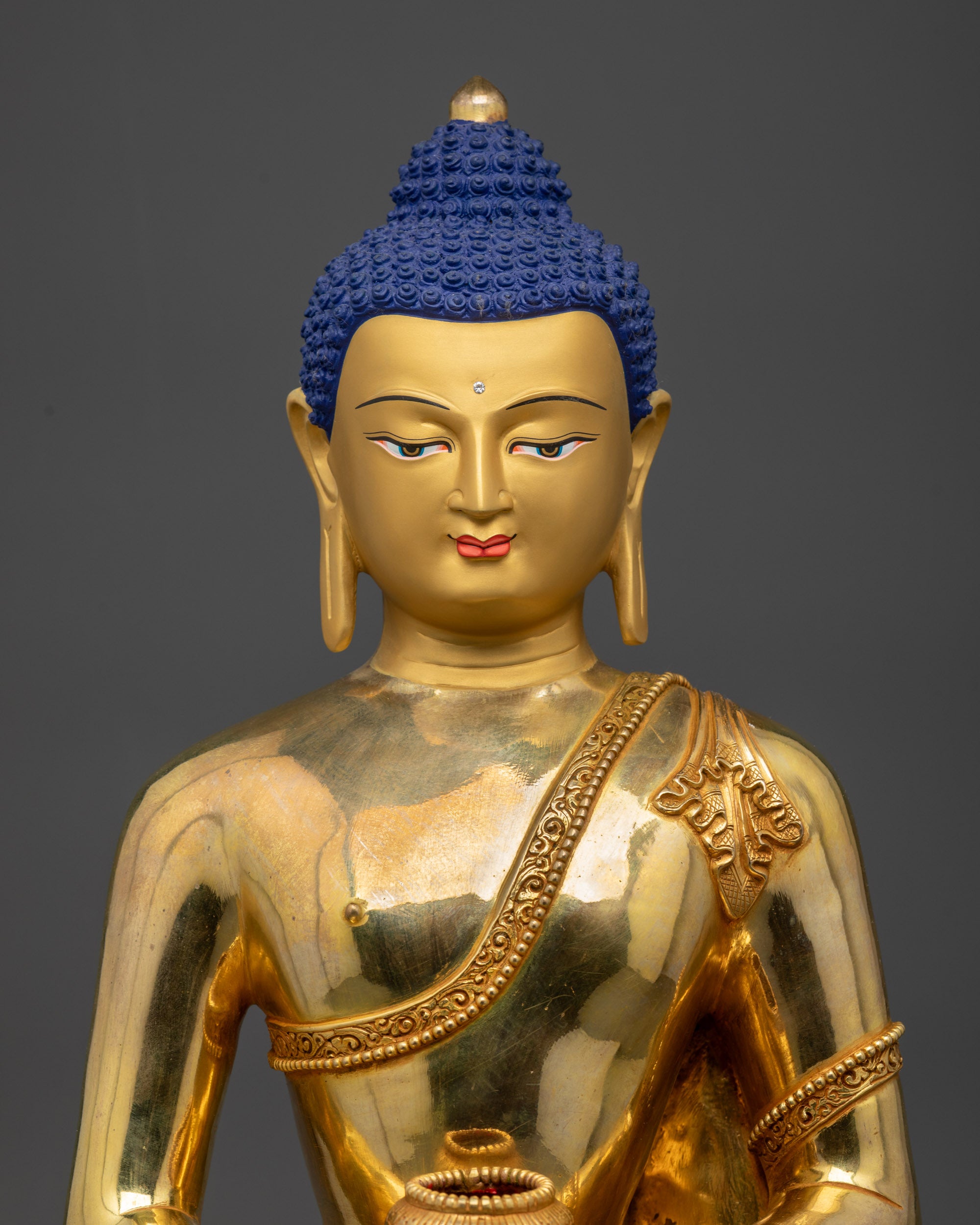 Close up of Amida Nyorai Buddha statue showing intricate robe carvings and semi-precious stones