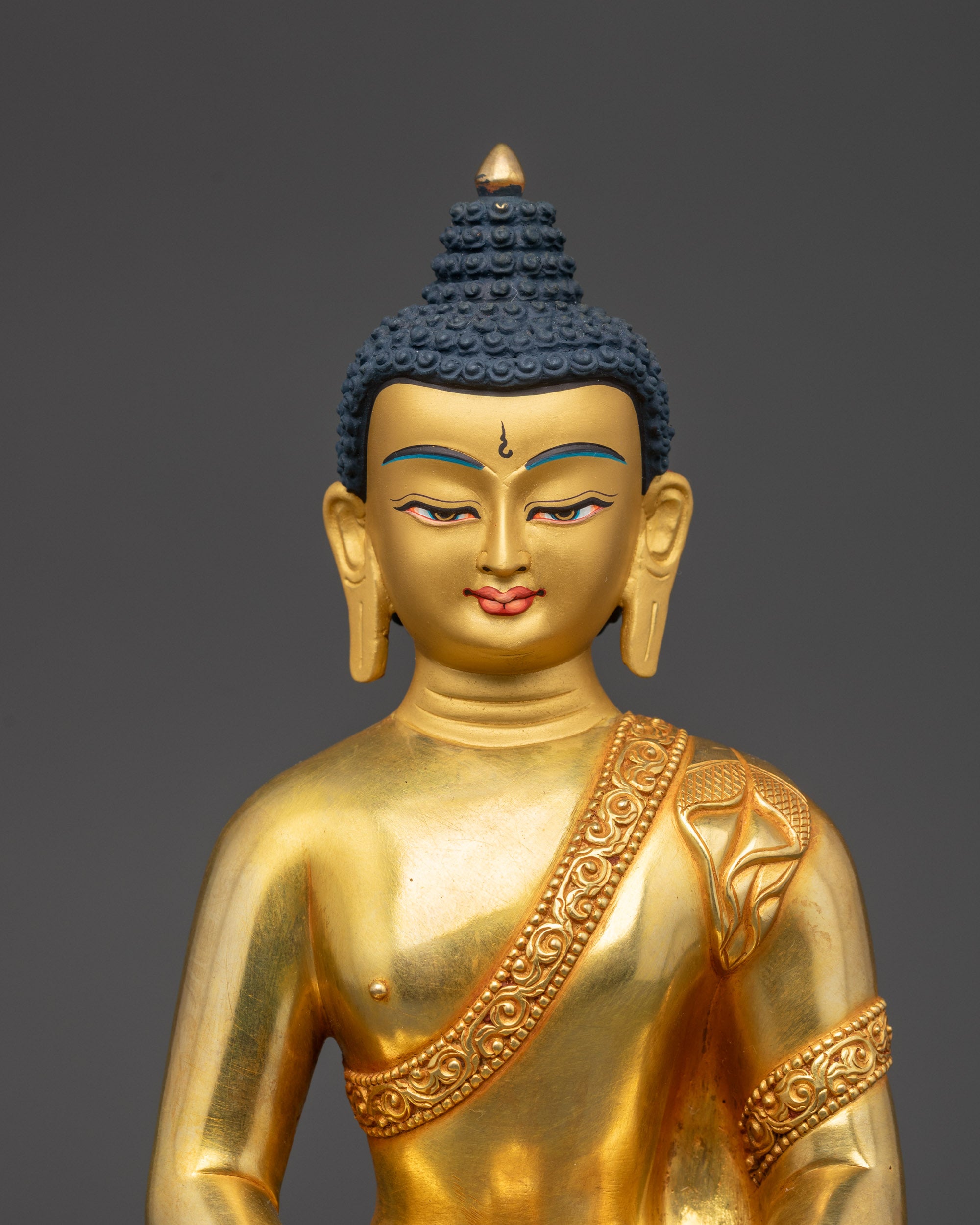 Close up of Amitabha Buddha statue face showing serene expression and detailed robe carvings