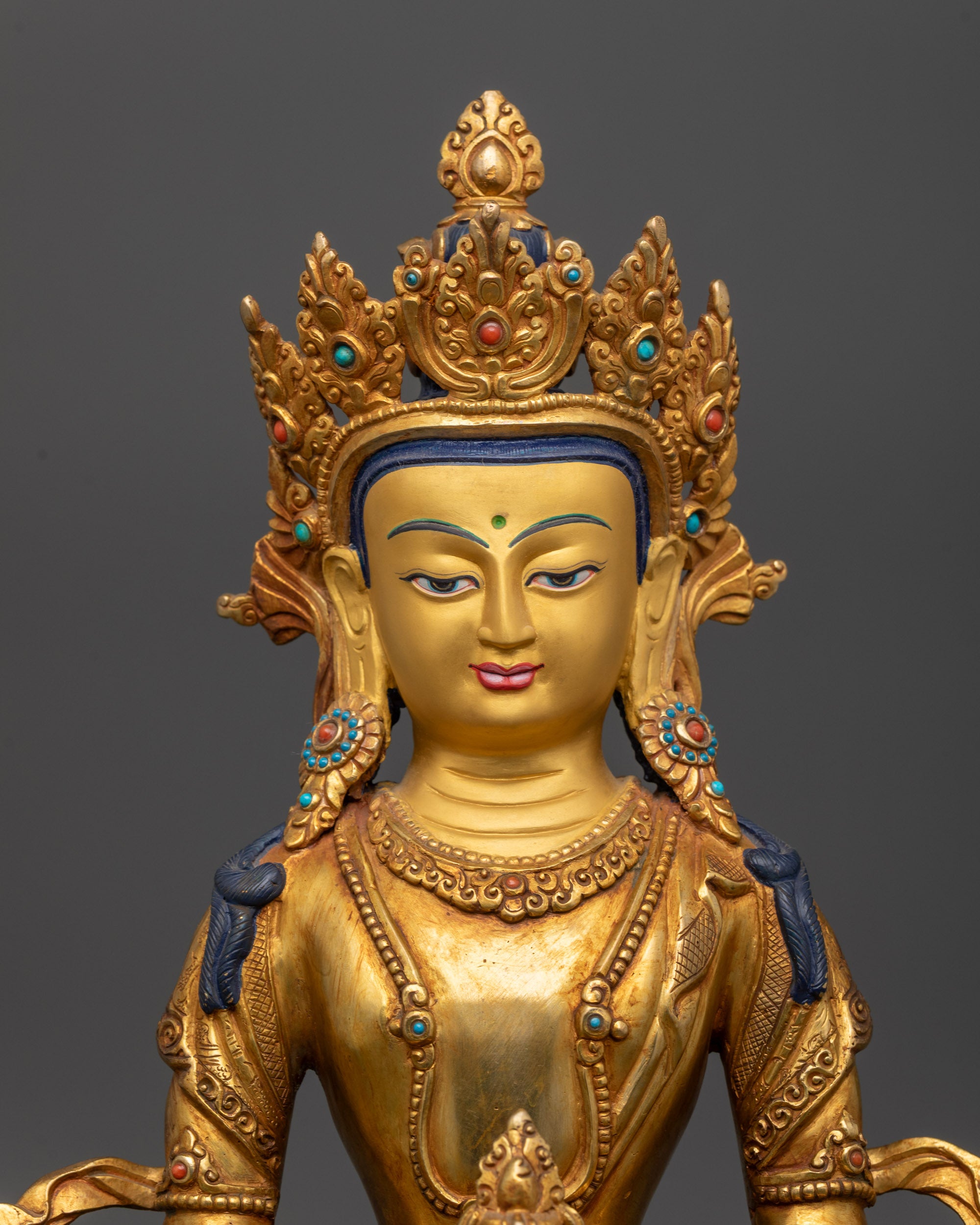 Close up of Amitayus Statue holding sacred nectar vase with gold fire-gilded body
