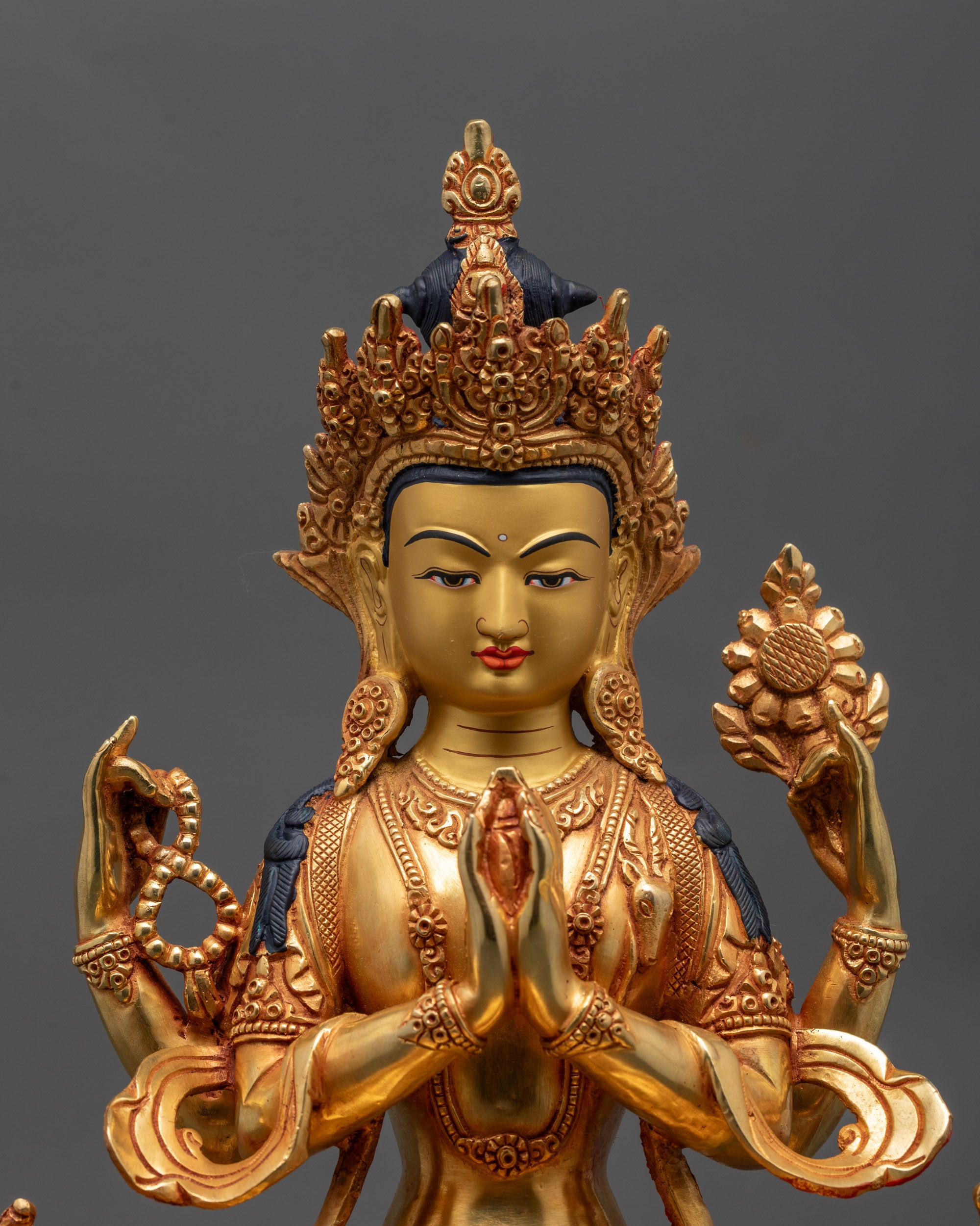 Close up of Avalokiteshvara Bodhisattva statue showing intricate copper and gold details
