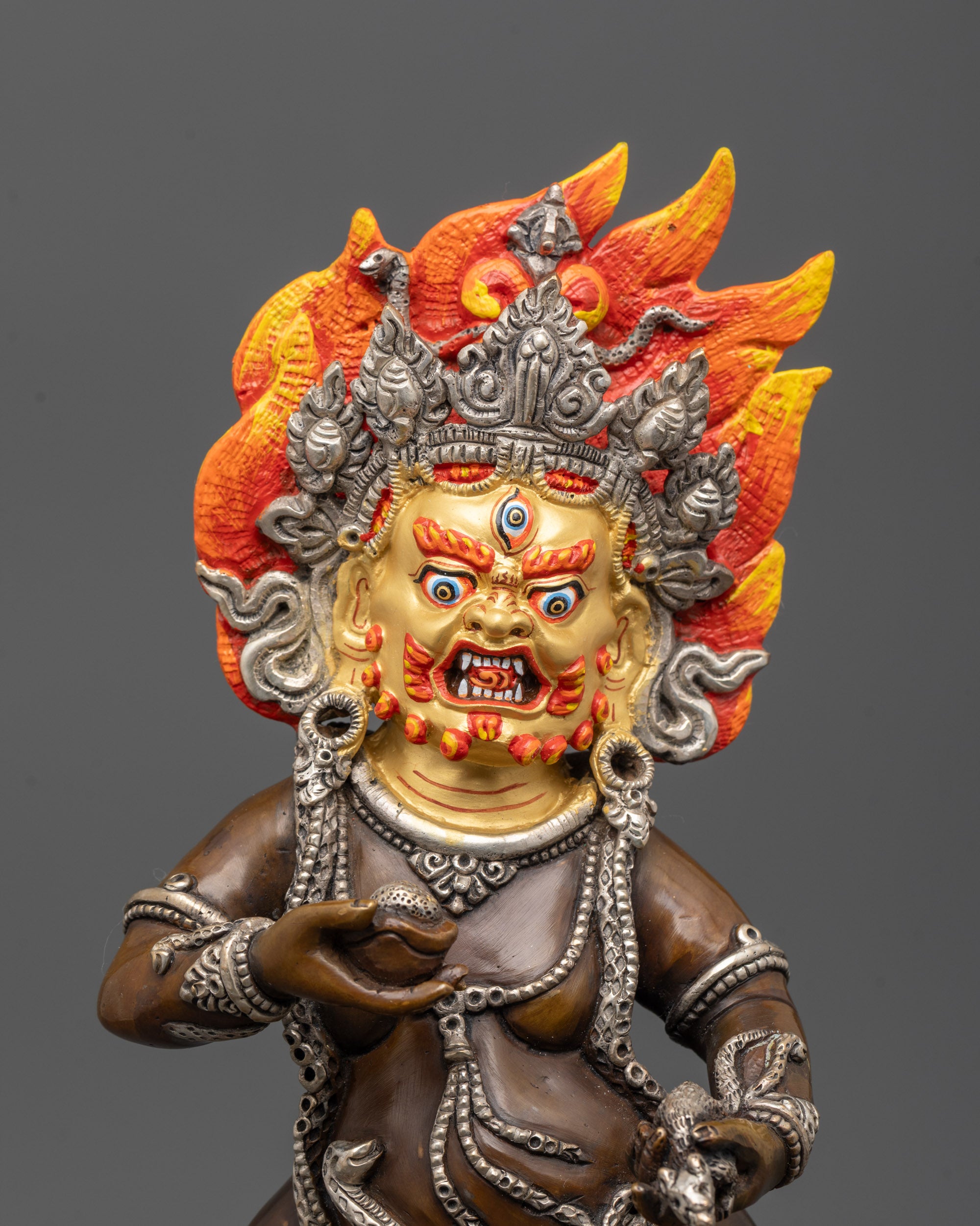 Close up of Black Dzambhala Statue showing jeweled spitting mongoose and kapala details
