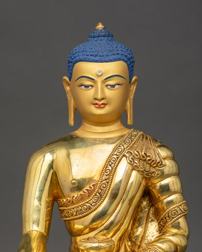 Close up of Buddha Shakyamuni Statue showing intricate robes and gold base