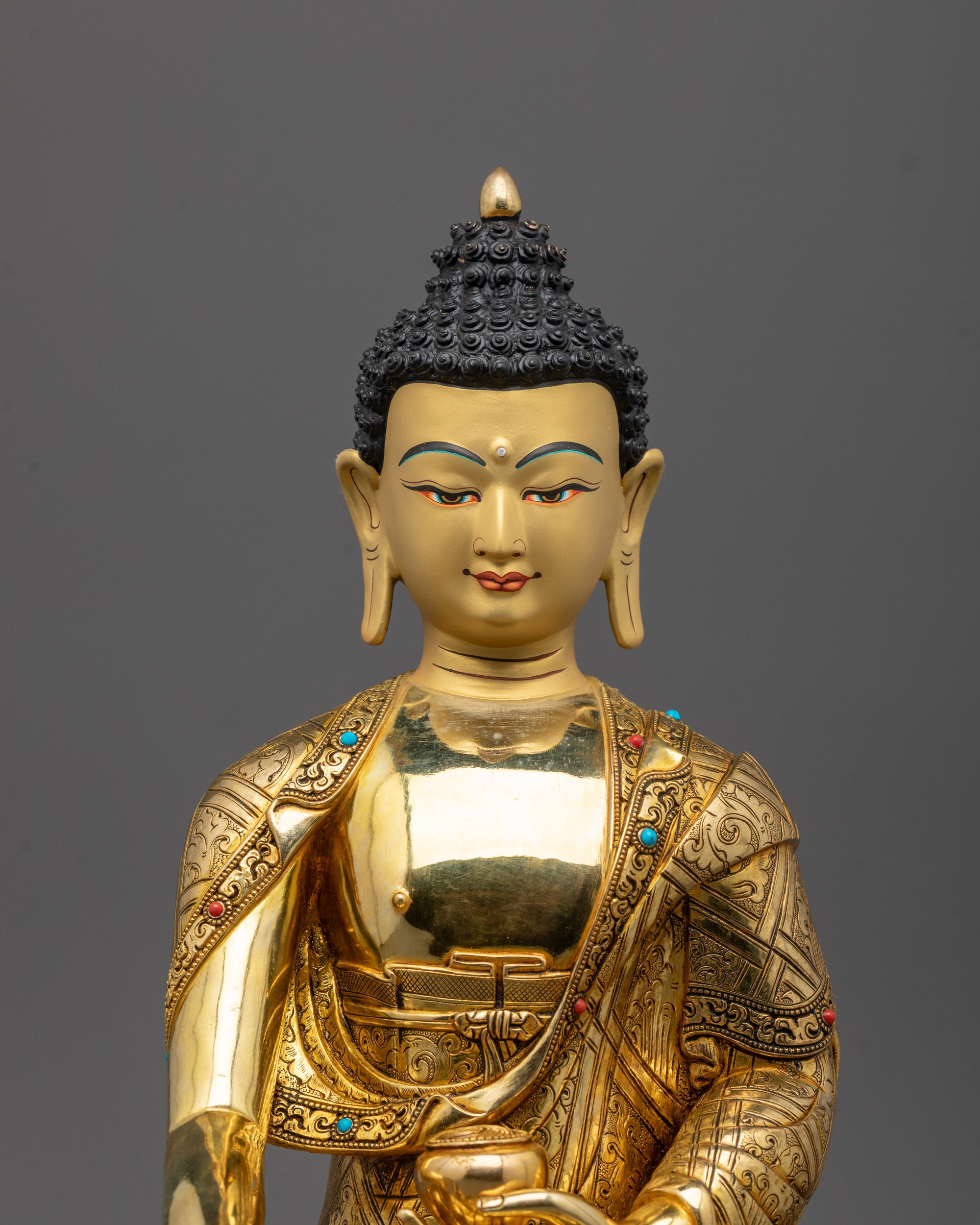 Close up of Buddha Shakyamuni statue’s gold fire-gilded copper body and intricate robes