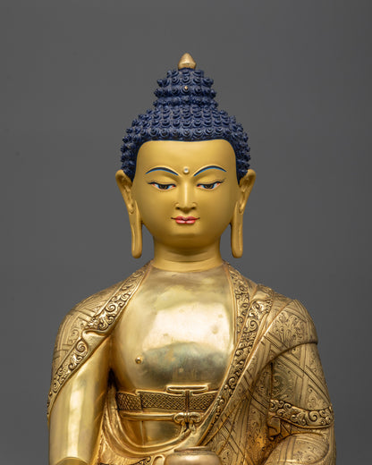 Close up of Buddha Shakyamuni statue showing gold-gilded face and intricate robe details