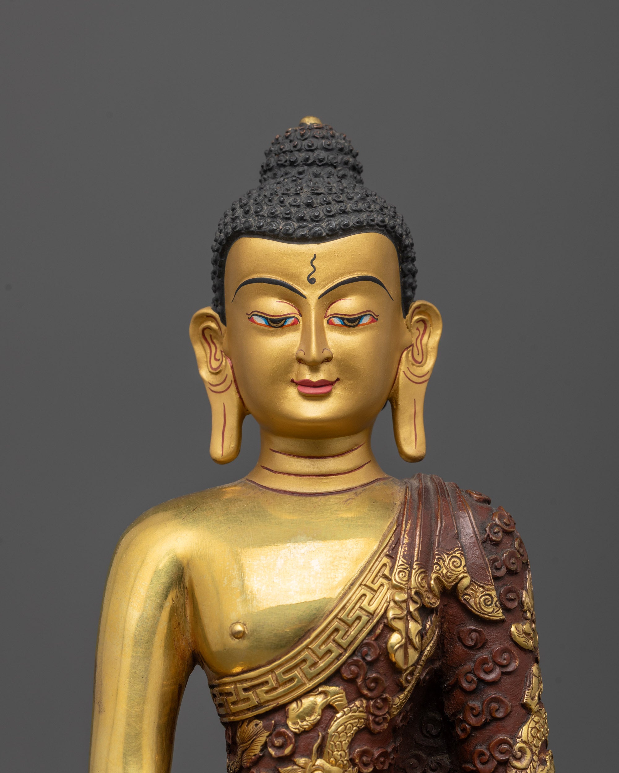 Close up of Buddha’s gold fire-gilded robe featuring carved dragons and clouds details