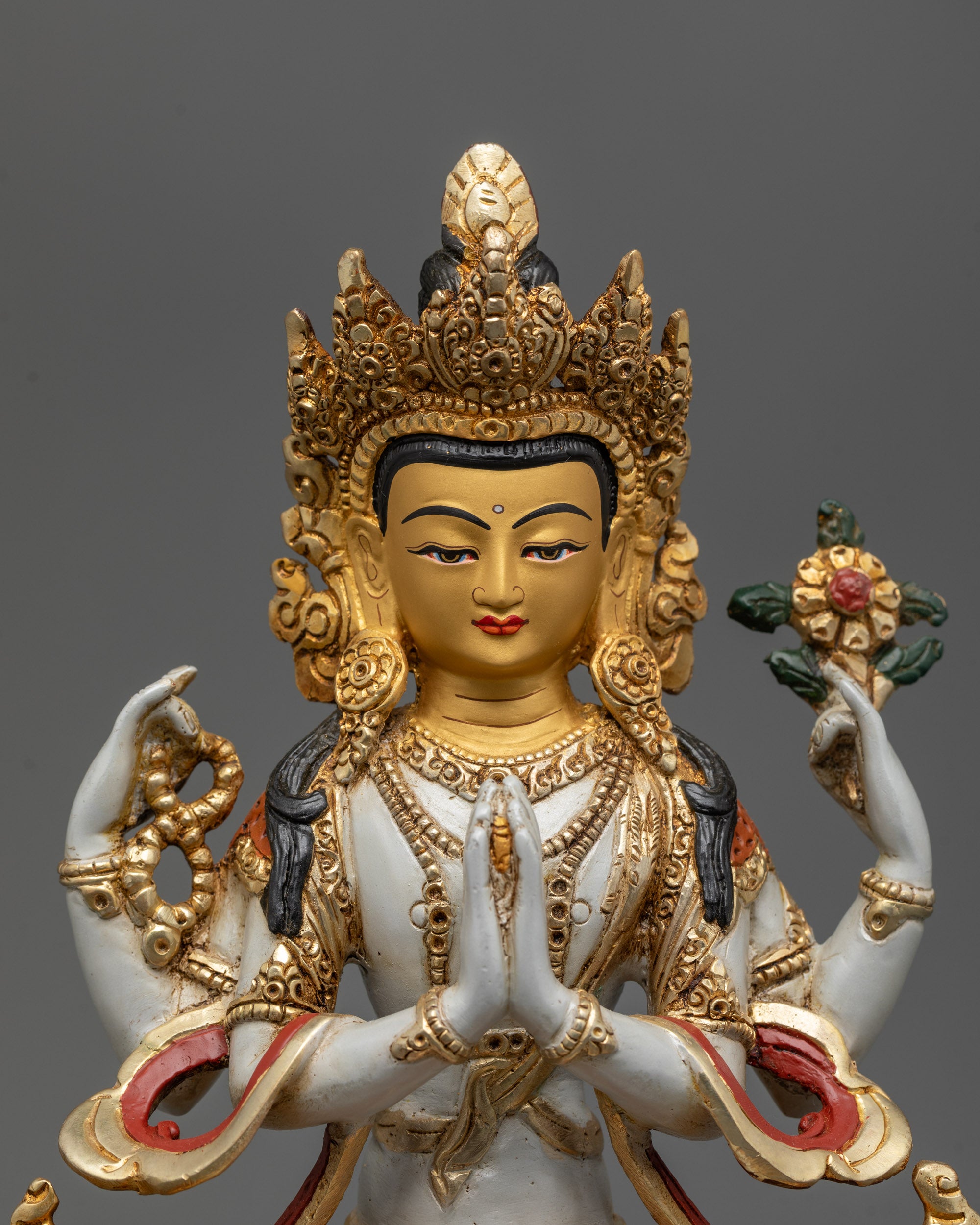 Close up of Chenrezig Statue showing four arms crystal rosary lotus and wish-fulfilling gem