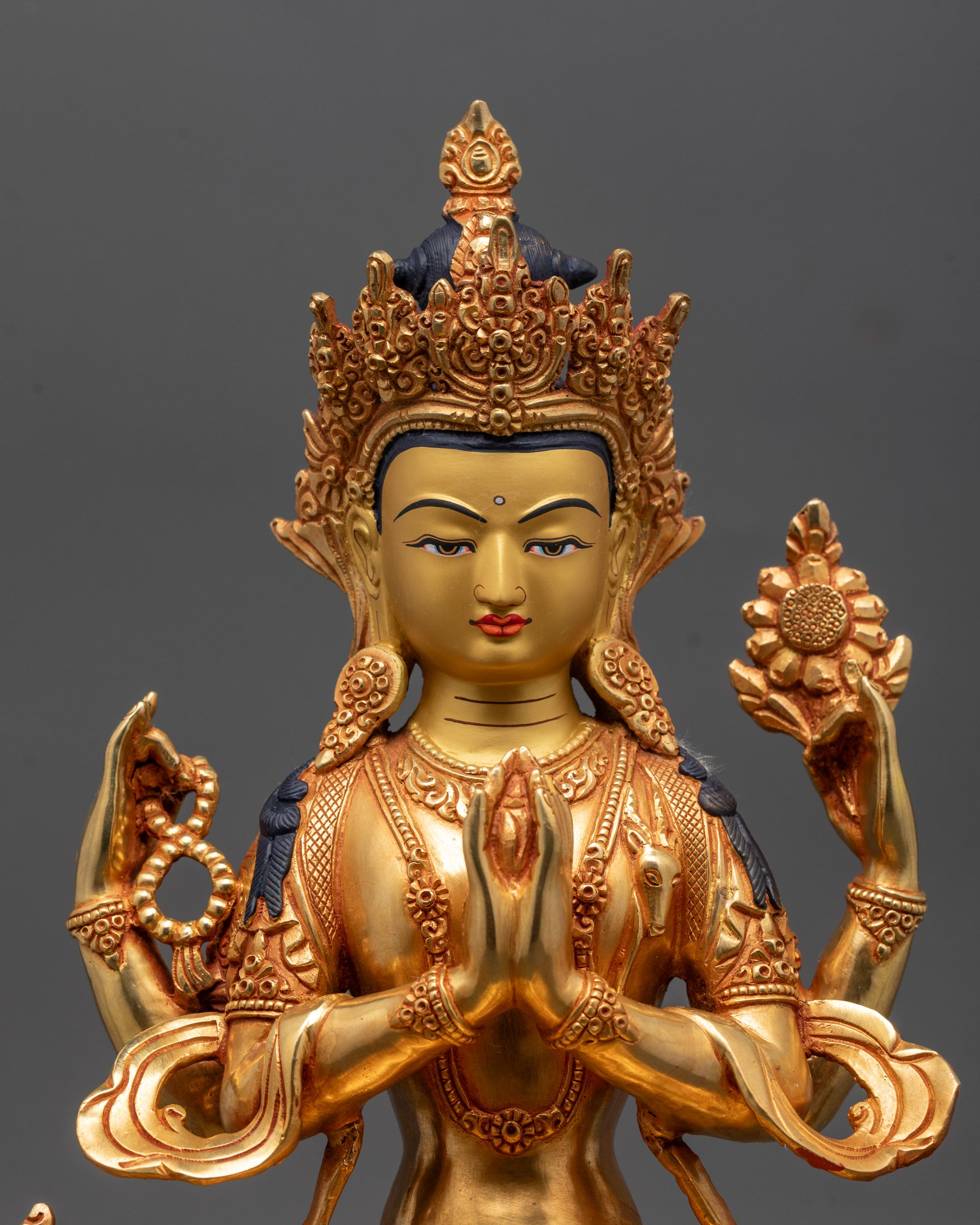 Close up of Chenrezig Statue showing intricate 24K gold details and sacred objects in hands