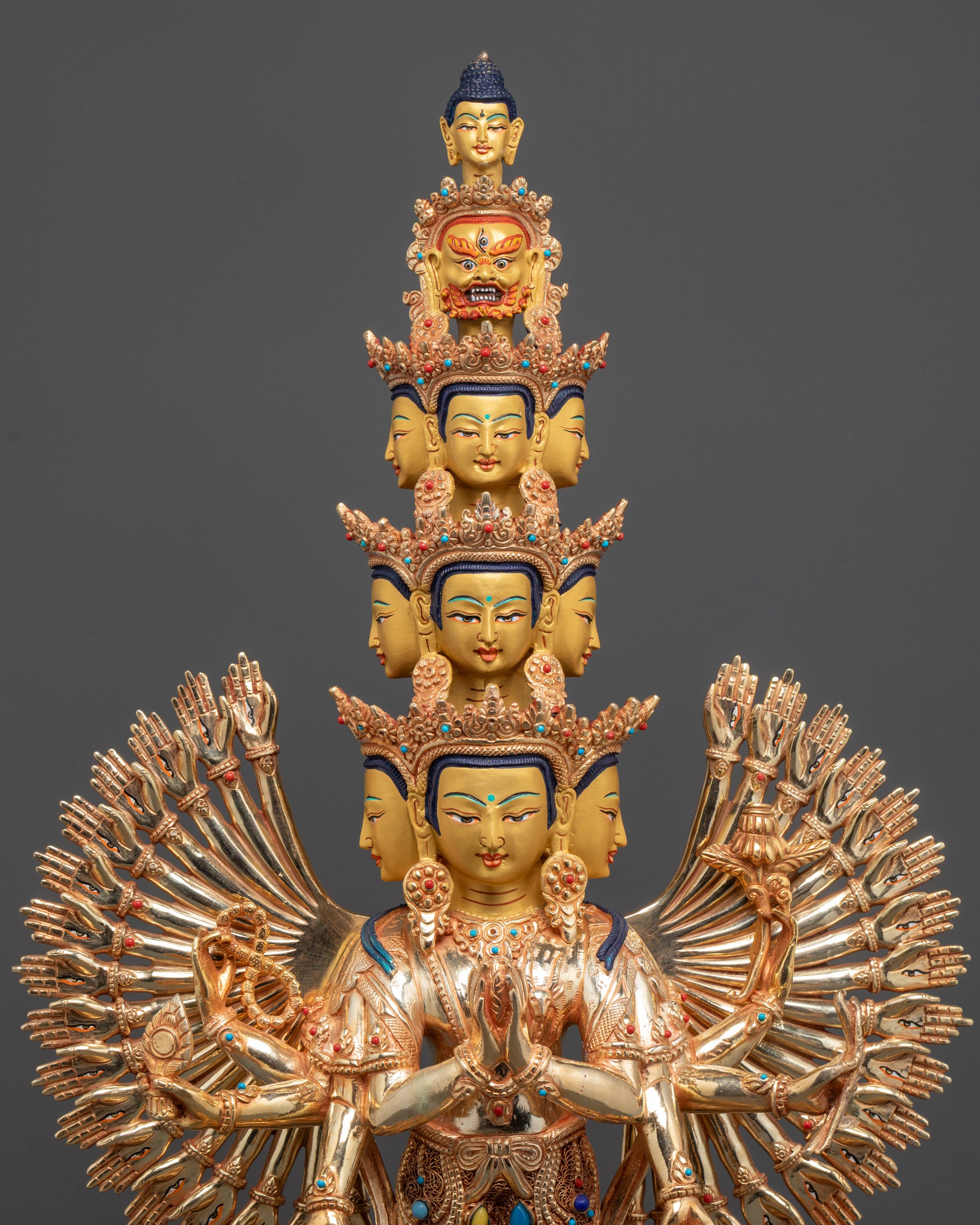 Close up of Chenrezig central hands holding wish-fulfilling jewel with peaceful face
