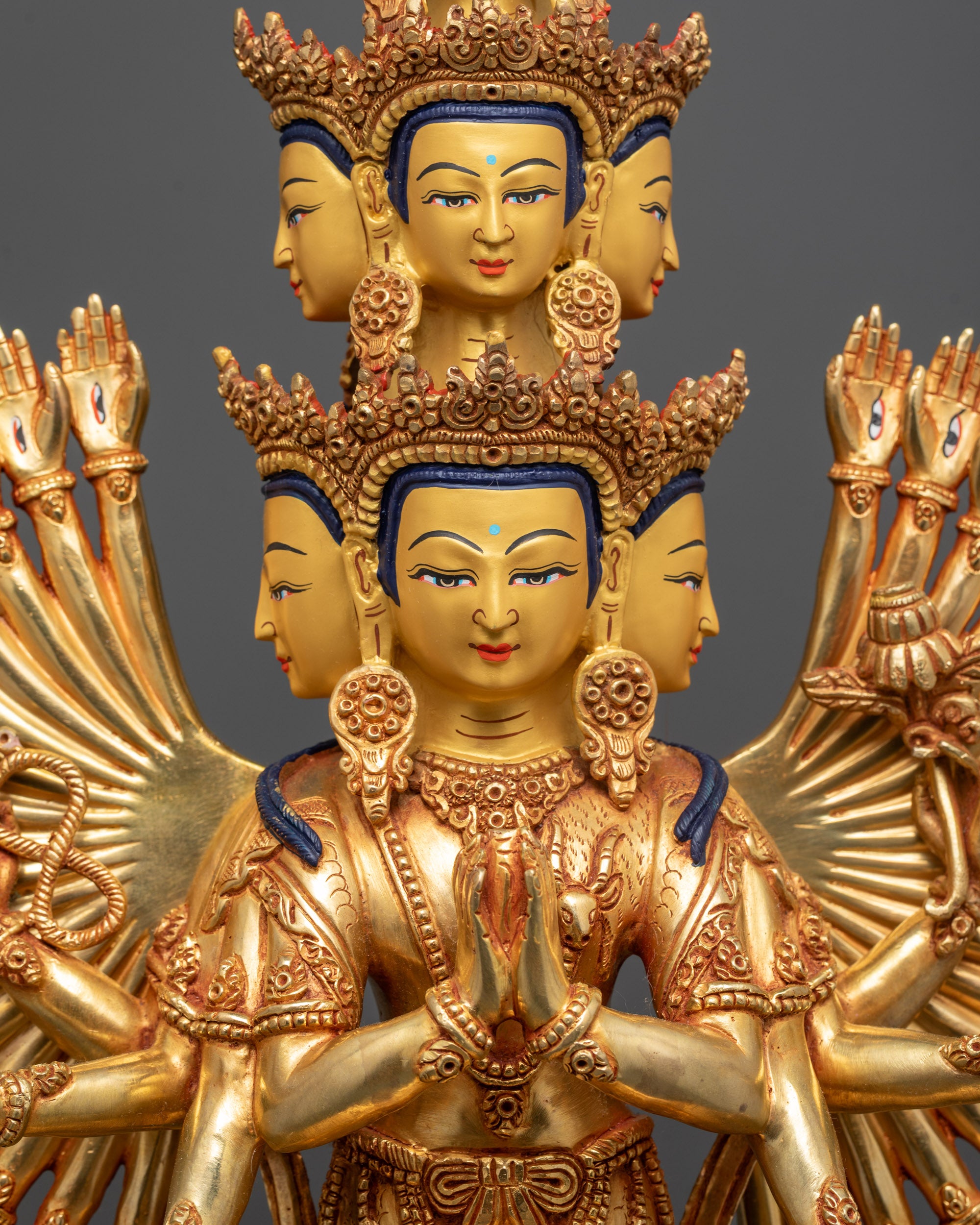 Close up of Chenrezig's central hands holding wish-fulfilling jewel and intricate arms