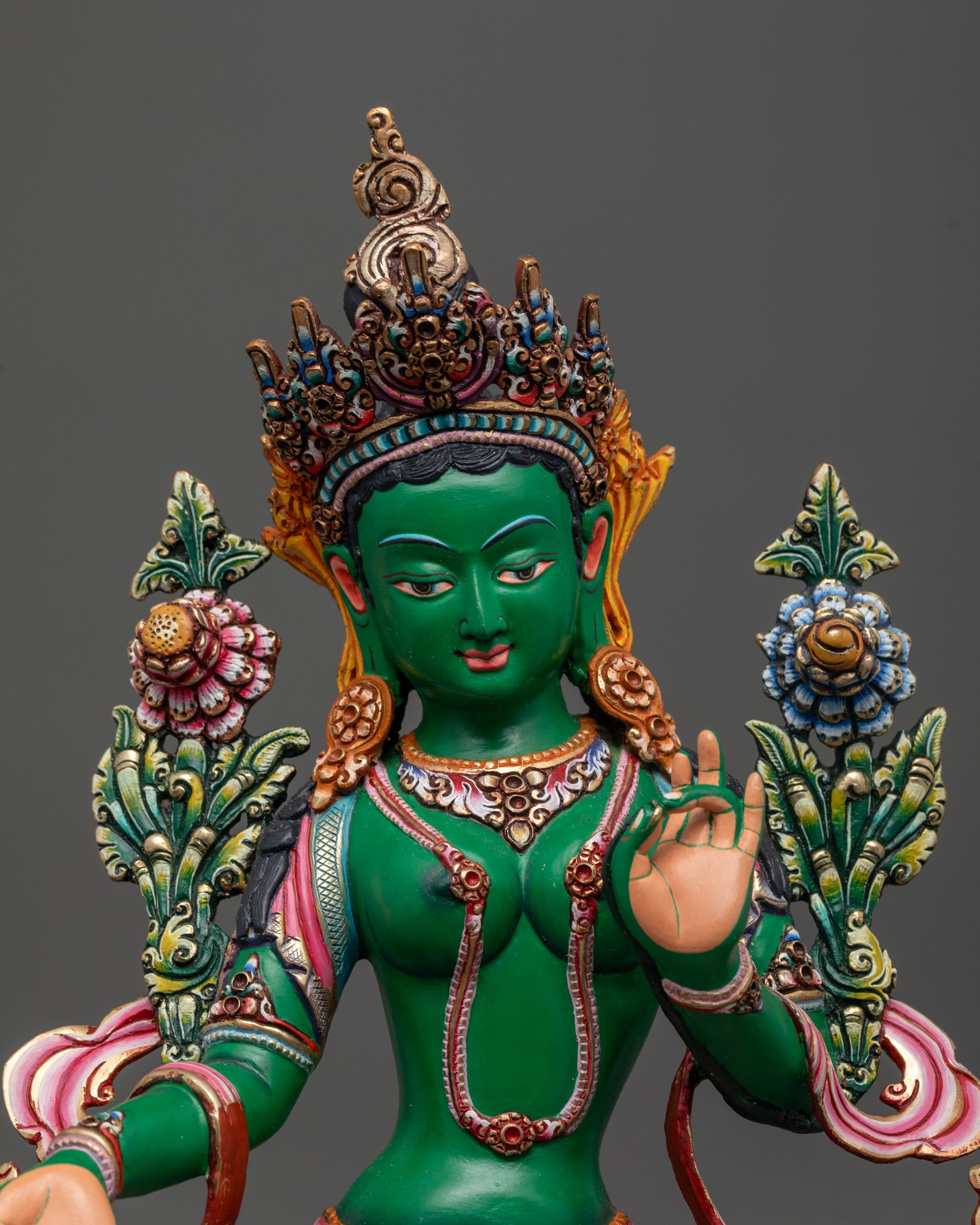 Close up of Coloured Green Tara holding utpala flower in Varada mudra with vibrant colors