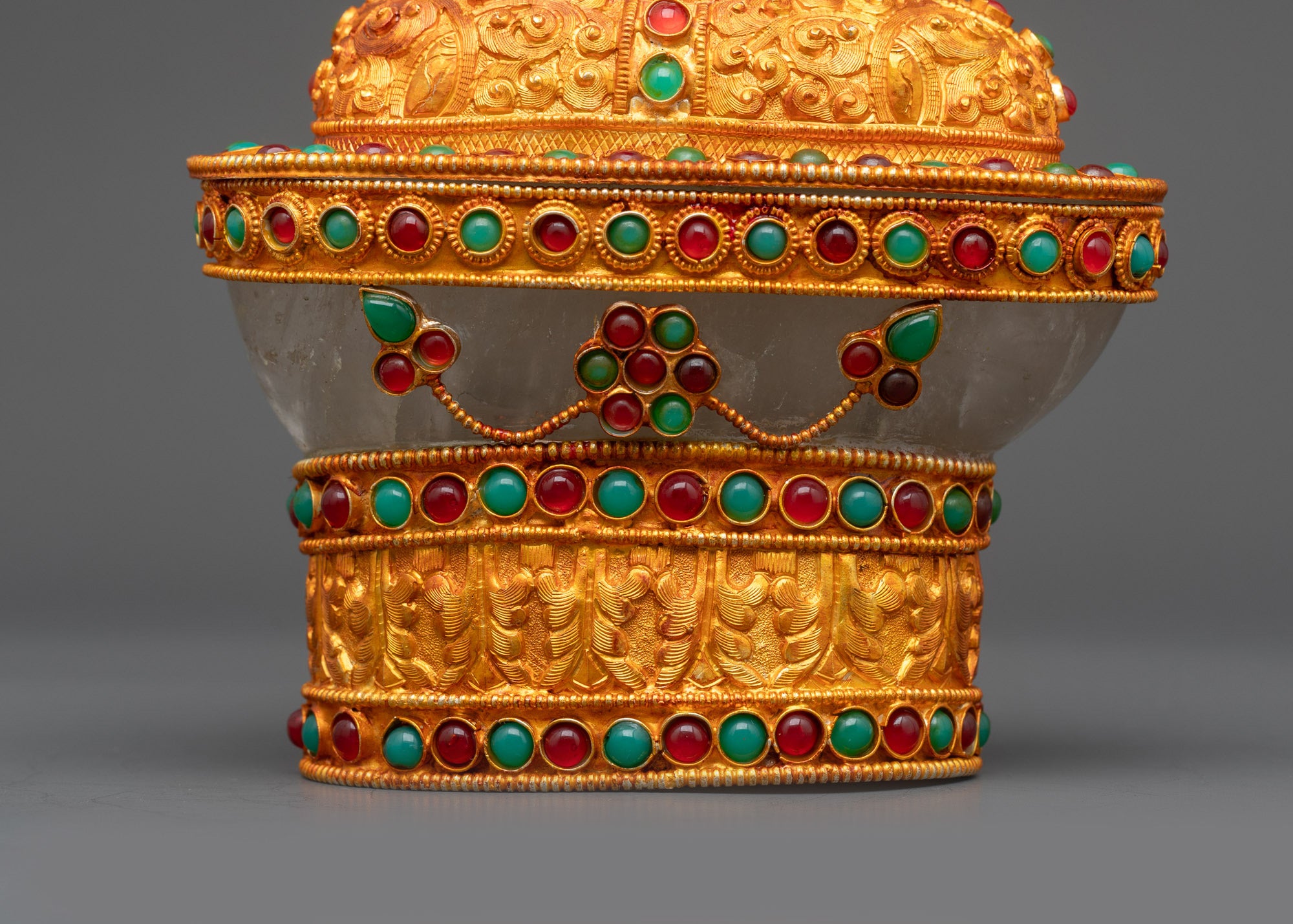 Close up of Crystal Kapala adorned with ruby emerald gemstones and carved motifs