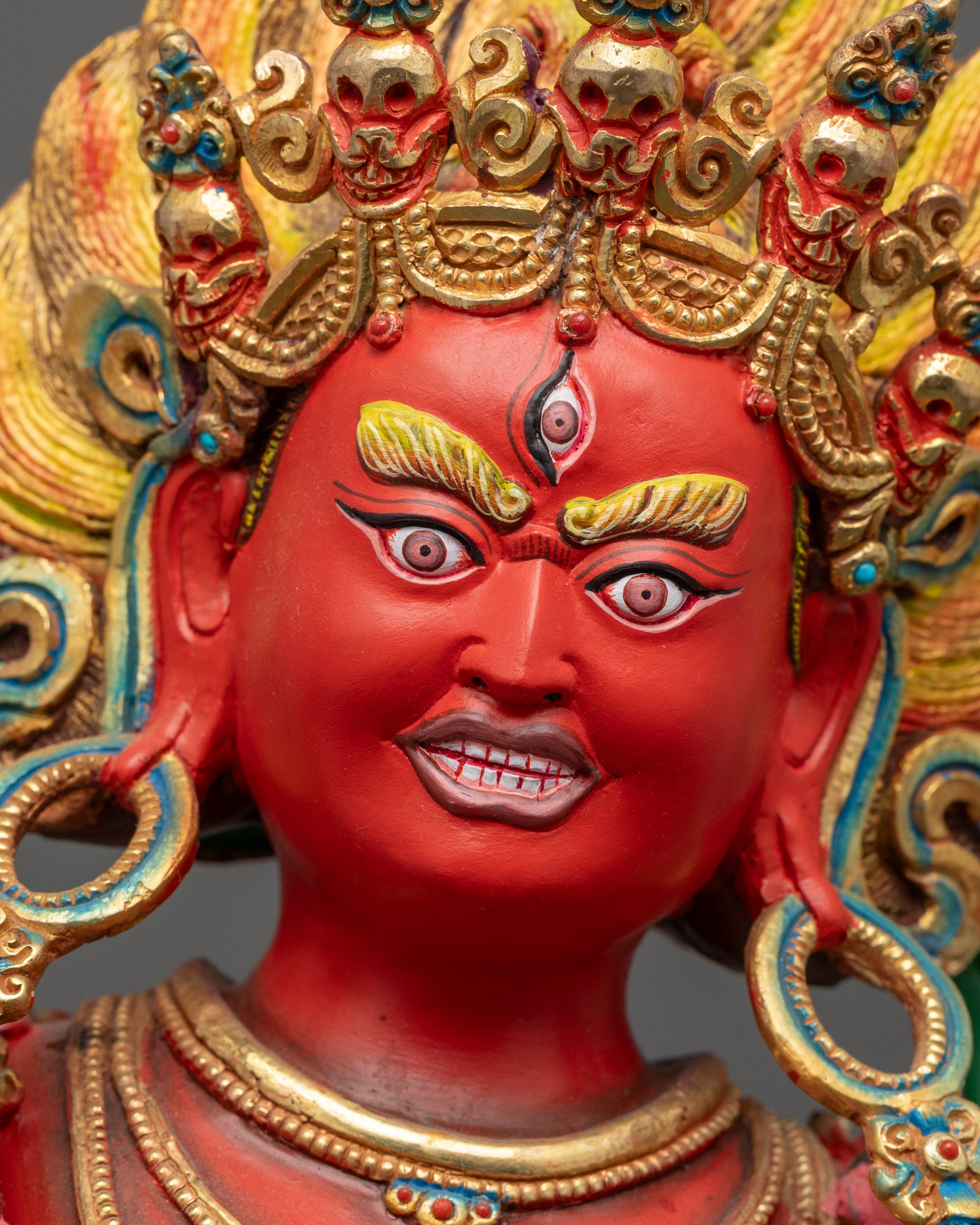 Close up of Dorje Phagmo face showing gold-gilded crown and fierce expression
