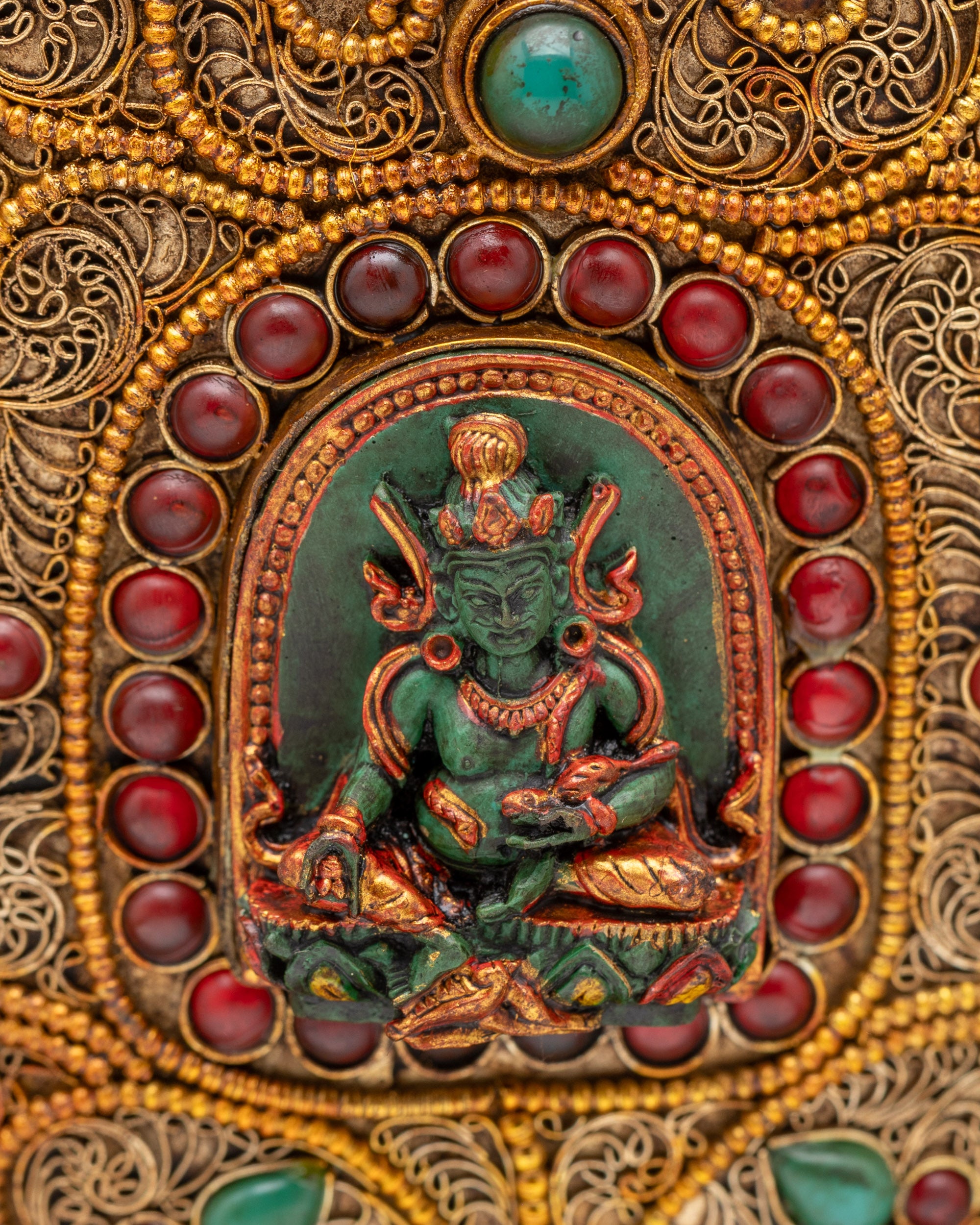 Close up of Dzambhala carving on sacred Himalayan rice pot
