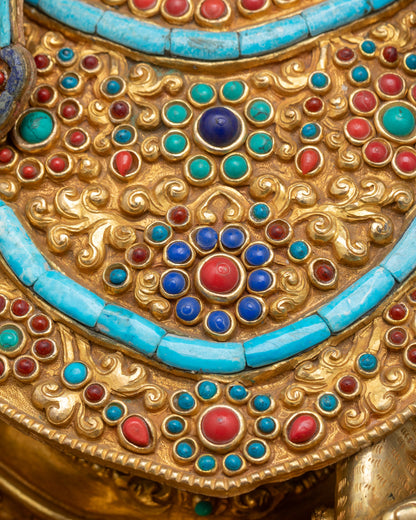 Close up of Dzambhala necklace with intricate motif patterns and semi-precious stones