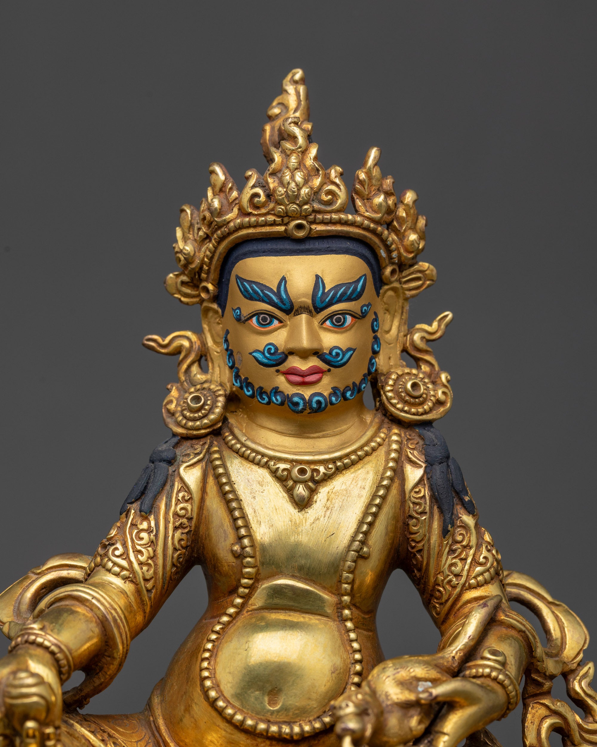 Close up of Dzambhala’s wrathful face, five-jeweled crown, and intricate jewelry
