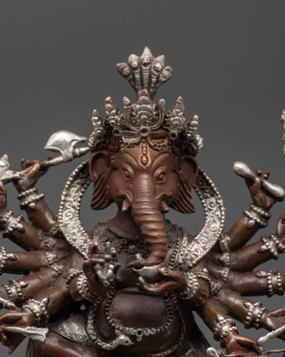Close up of Ganesh Murti showing twelve arms holding sacred objects and third eye