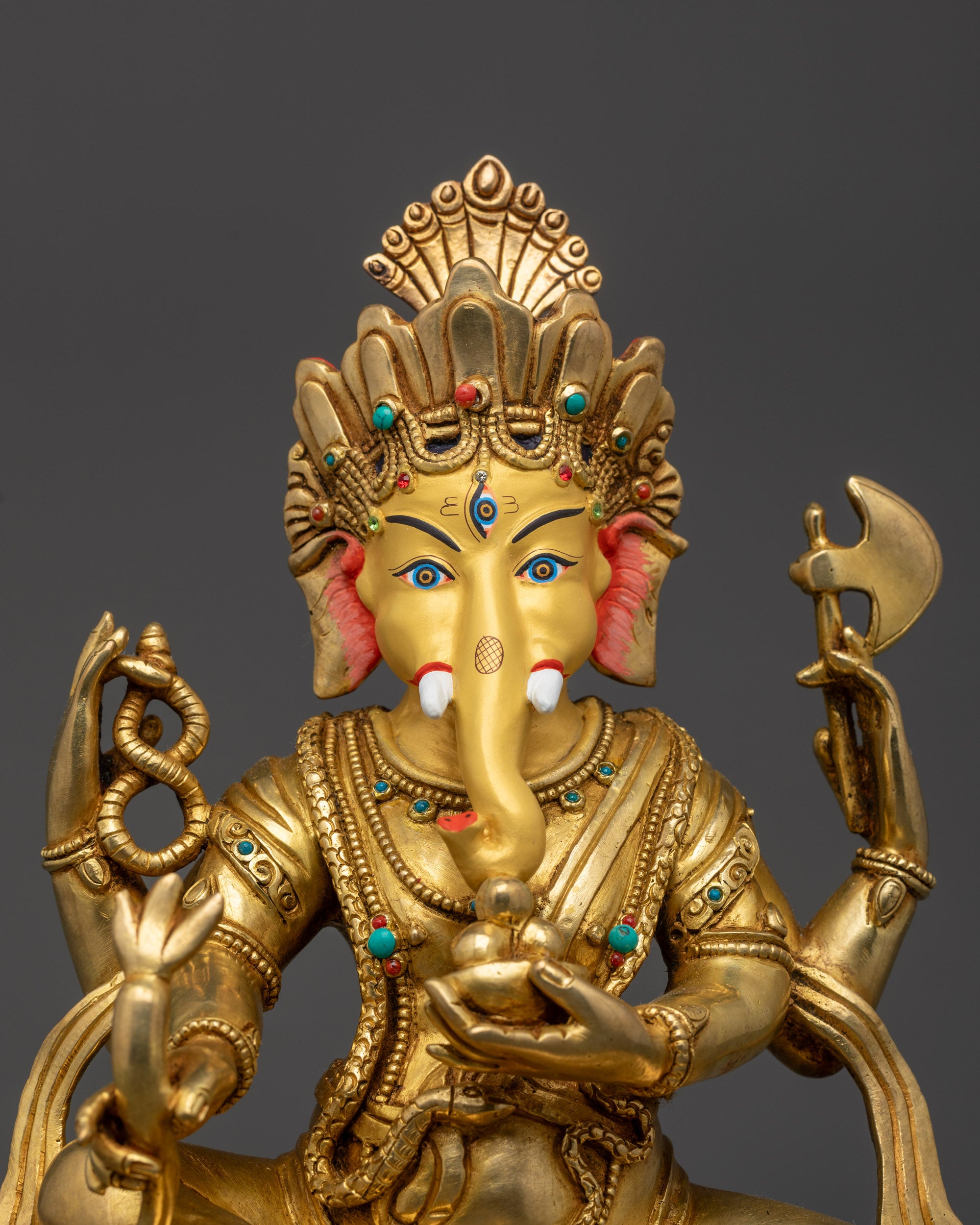 Close up of Ganesha’s gold-gilded face and third eye on forehead