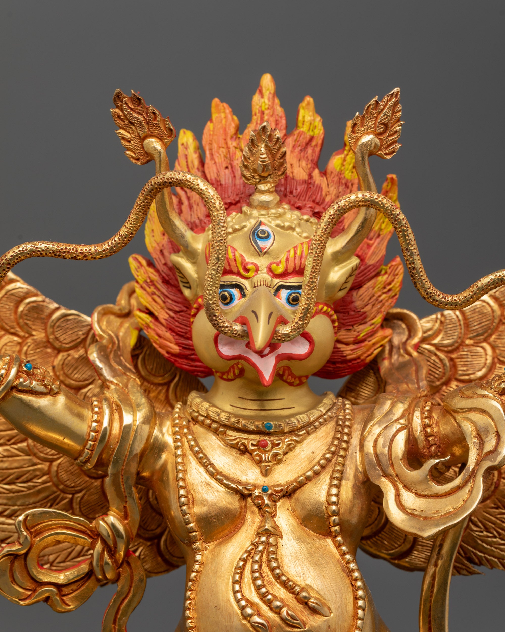Close up of Garuda Dev Statue showing five-skull crown wings and ornate jewellery
