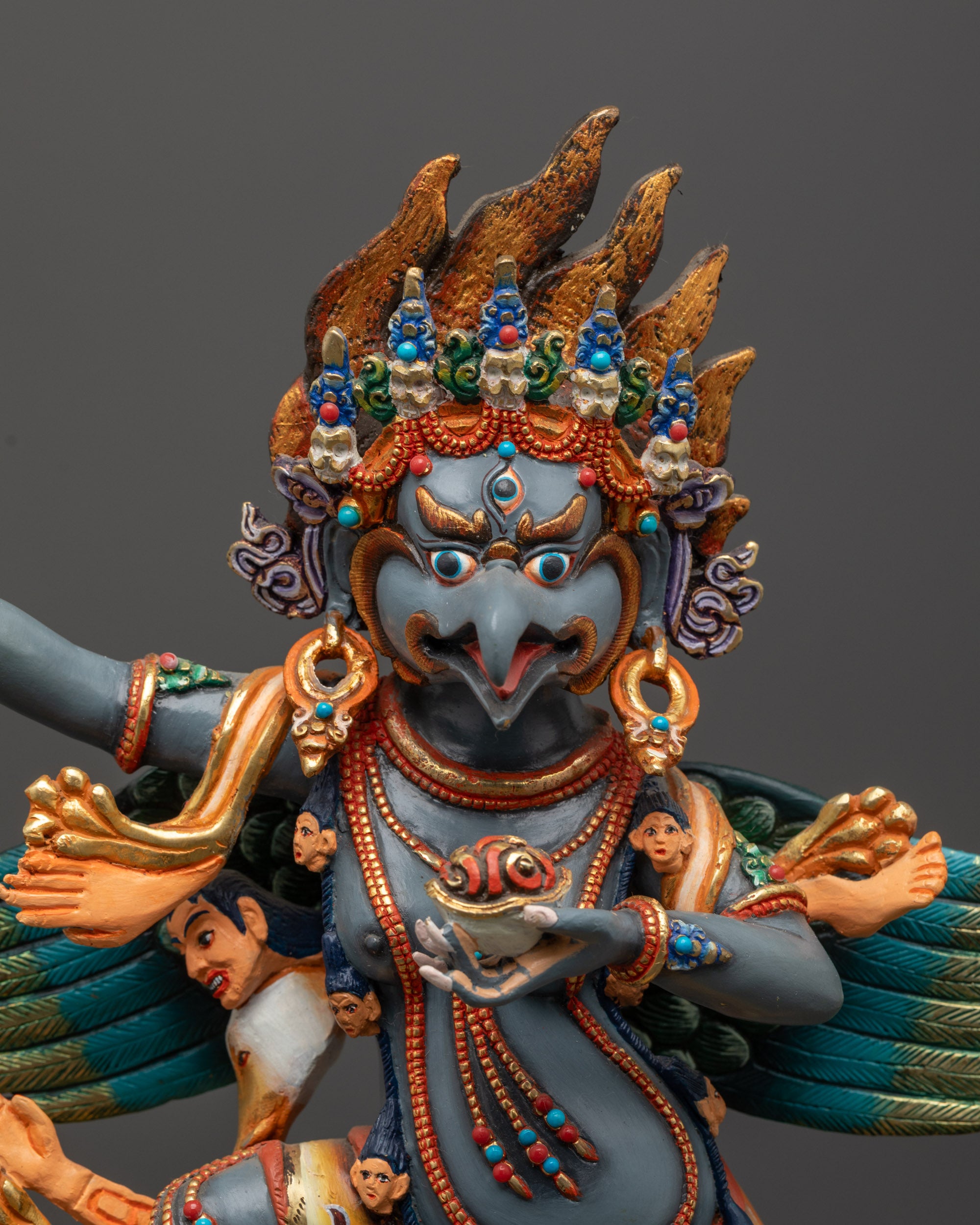 Close up of Garuda Statue showing five-skull crown and detailed jewelry

