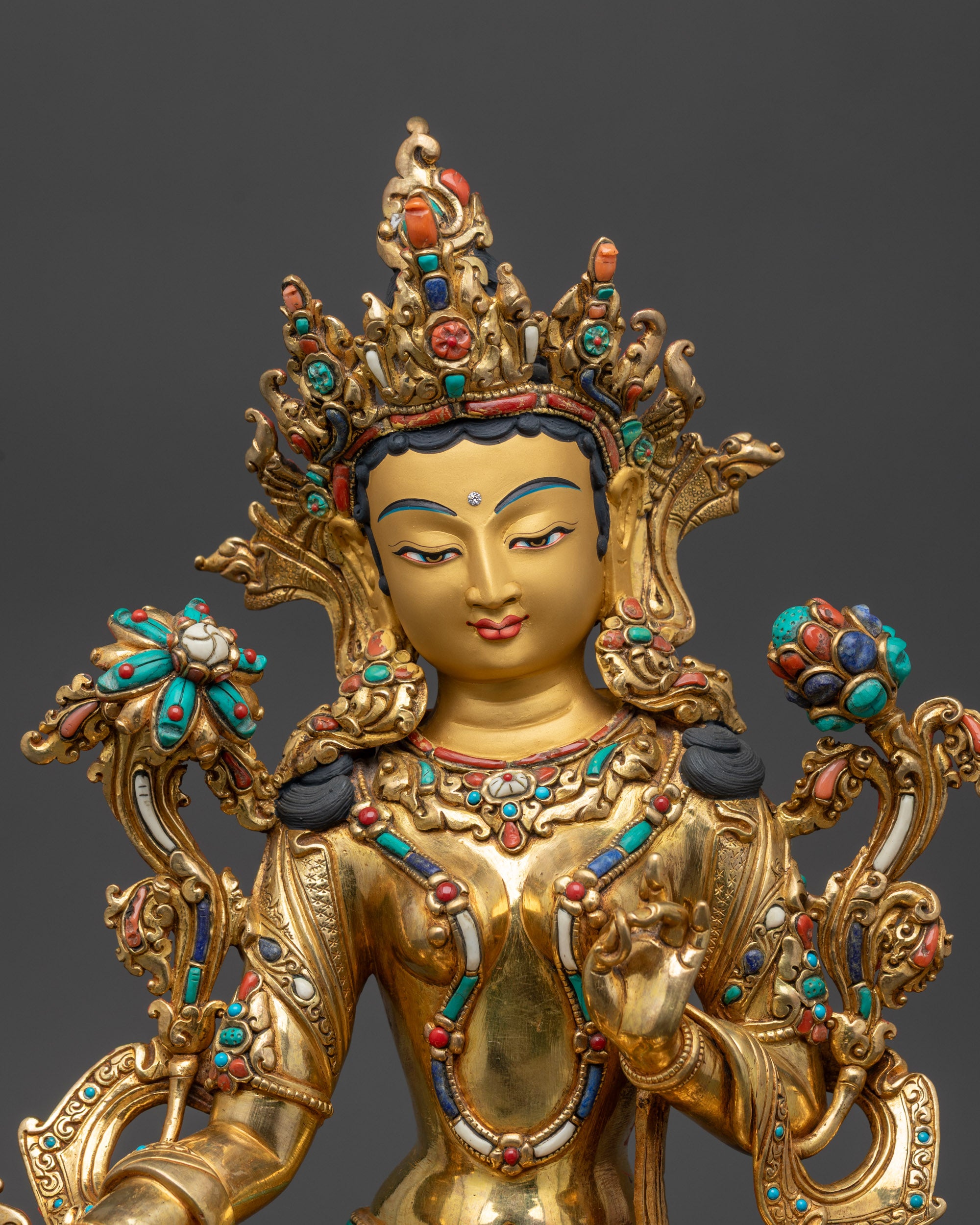 Close up of Green Tara Statue showing five-jeweled crown, utpala flower, and serene expression
