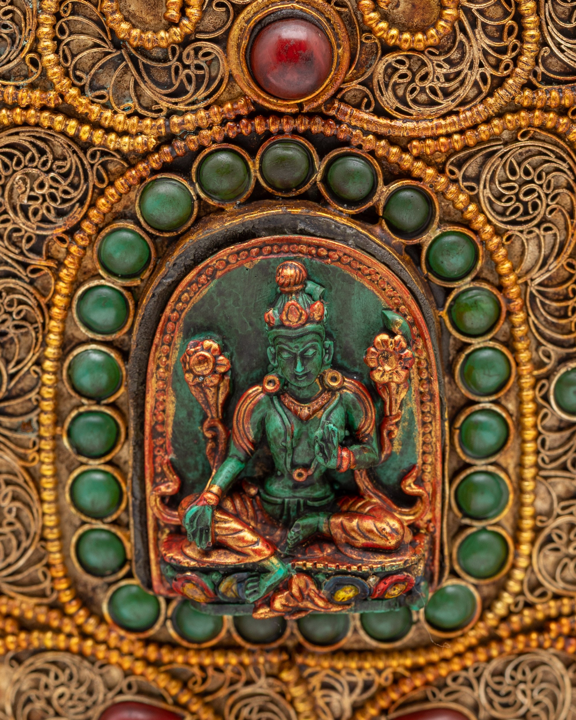 Close up of Green Tara carving on Tibetan rice pot