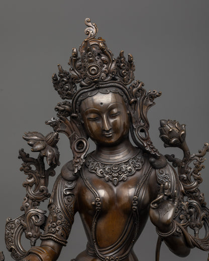 Close up of Green Tara face showing serene expression and detailed five-jeweled crown