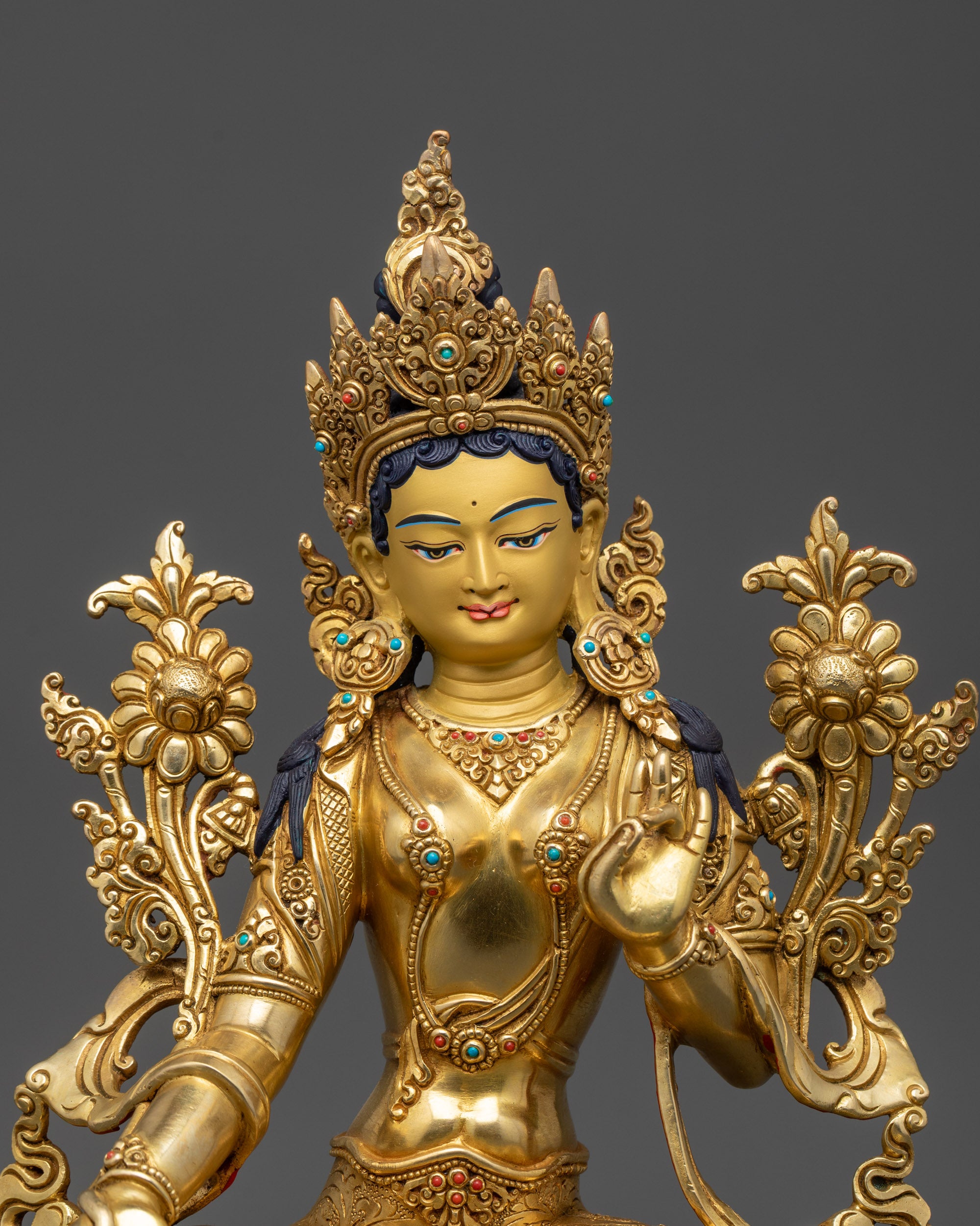 Close up of Green Tara face showing serene expression and five-jeweled crown details
